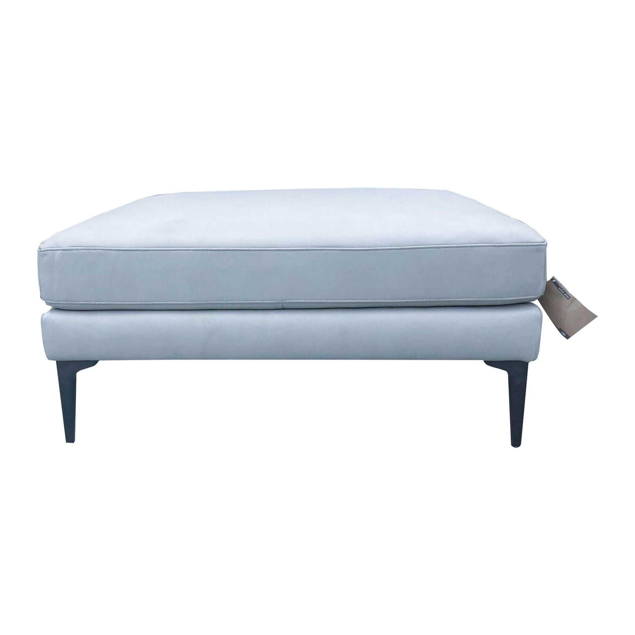 1. Grey square ottoman or coffee table by West Elm with cushioned top and angled metal legs.
