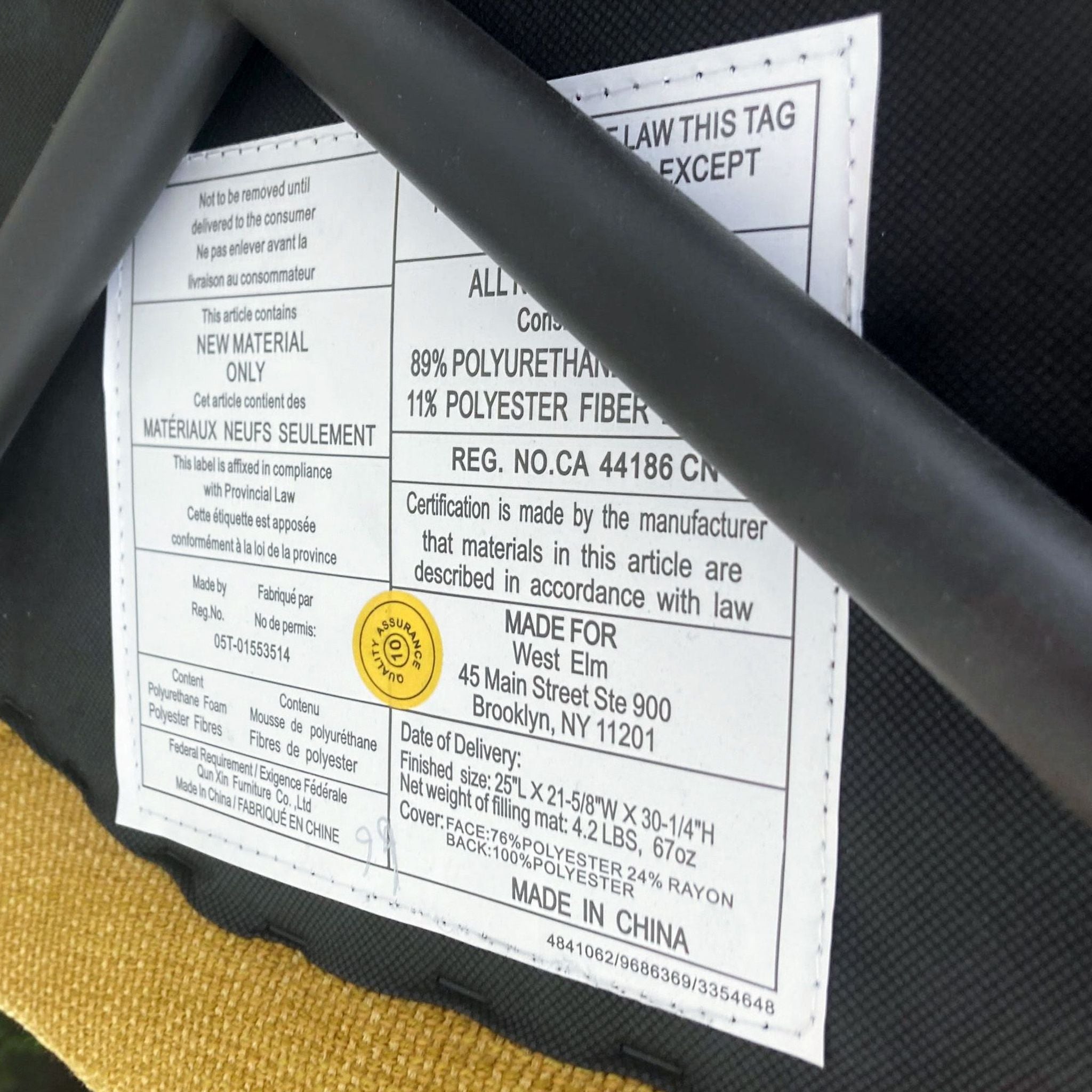 Labels on a West Elm dining chair showing material composition and care instructions, with a focus on a 'FRONT' indicator sticker.
