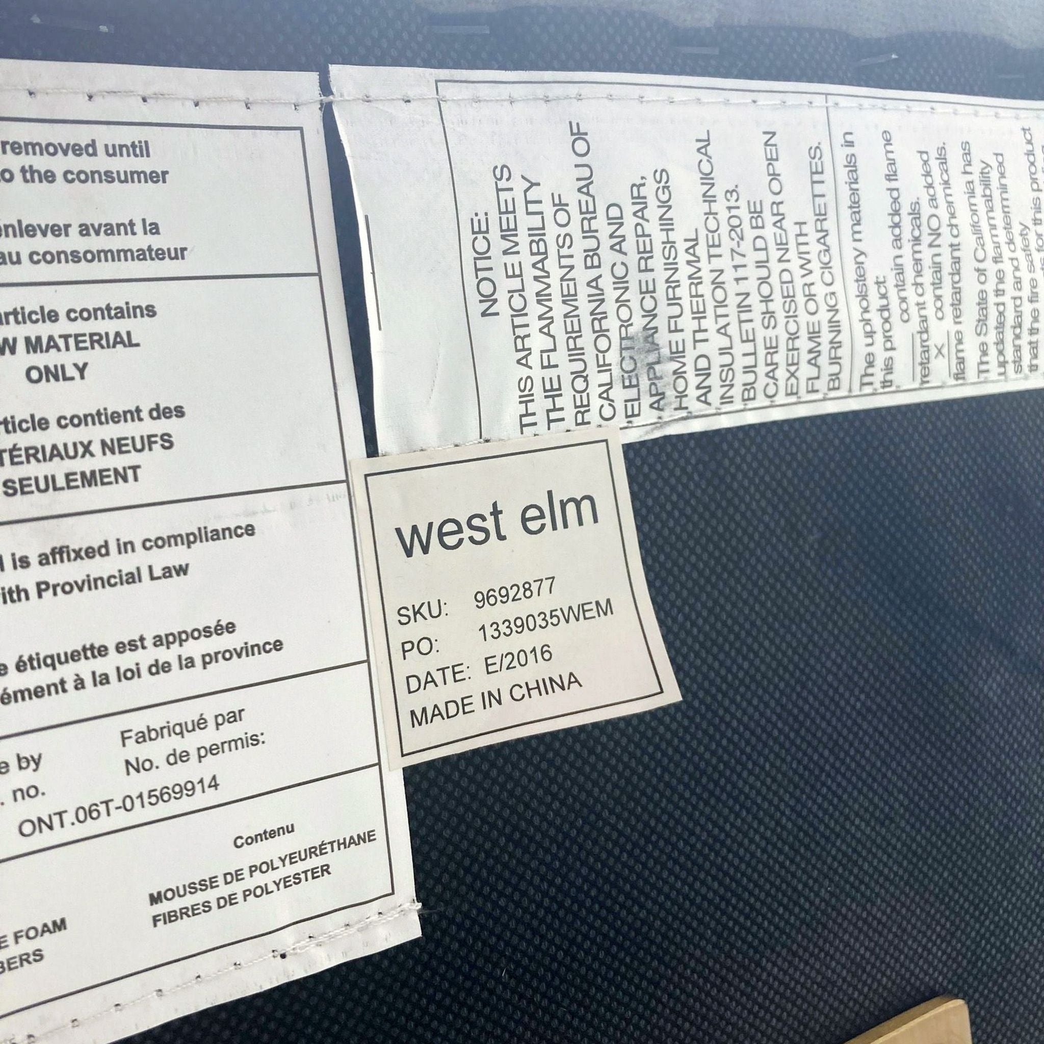 Alt text: Close-up of West Elm labels on the Roar & Rabbit designed lounge chair, showcasing the SKU number and compliance information.