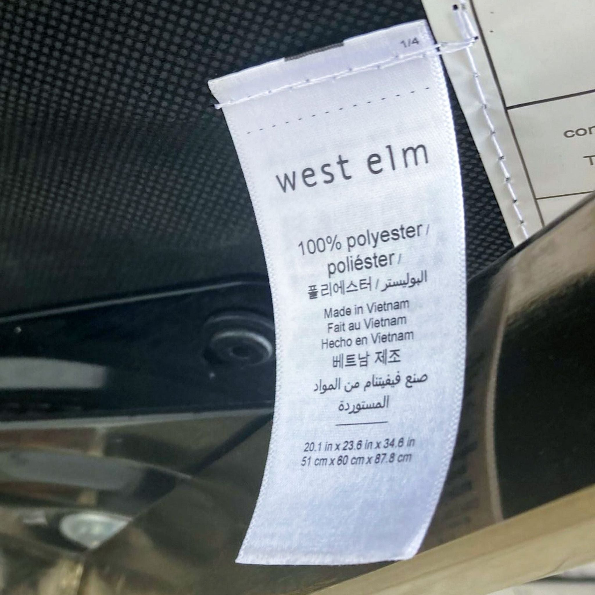 Close-up of a West Elm label showing material and manufacturing details in multiple languages.