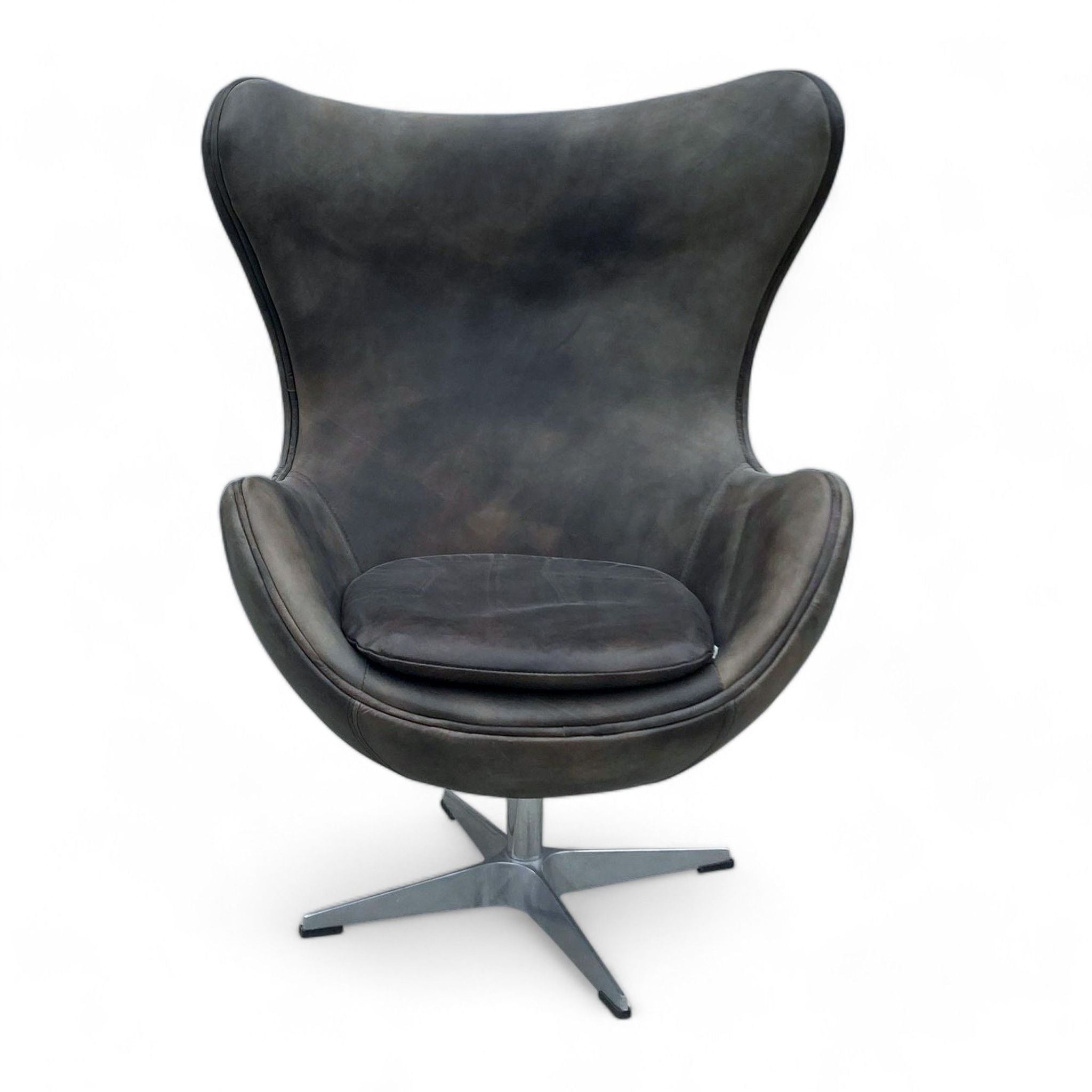 Sleek modern lounge chair by Restoration Hardware, featuring leather upholstery and a metal swivel base.