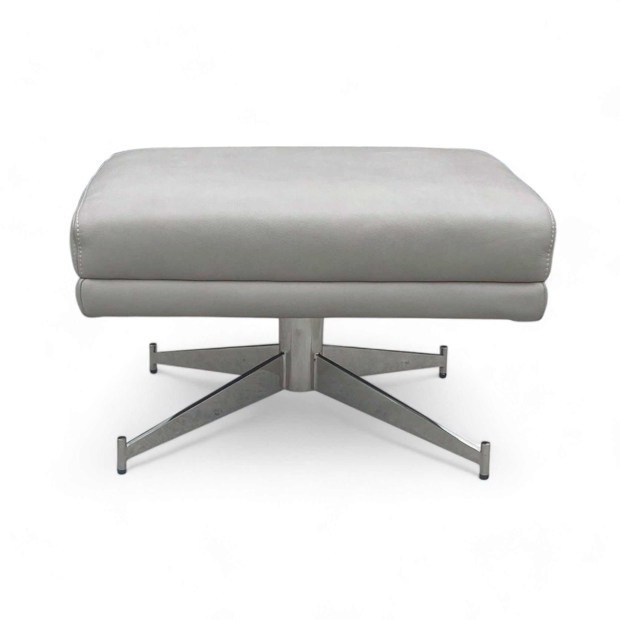 3. Side view of a West Elm Austin Ottoman highlighting the cushioned top and sturdy chrome X-base design.