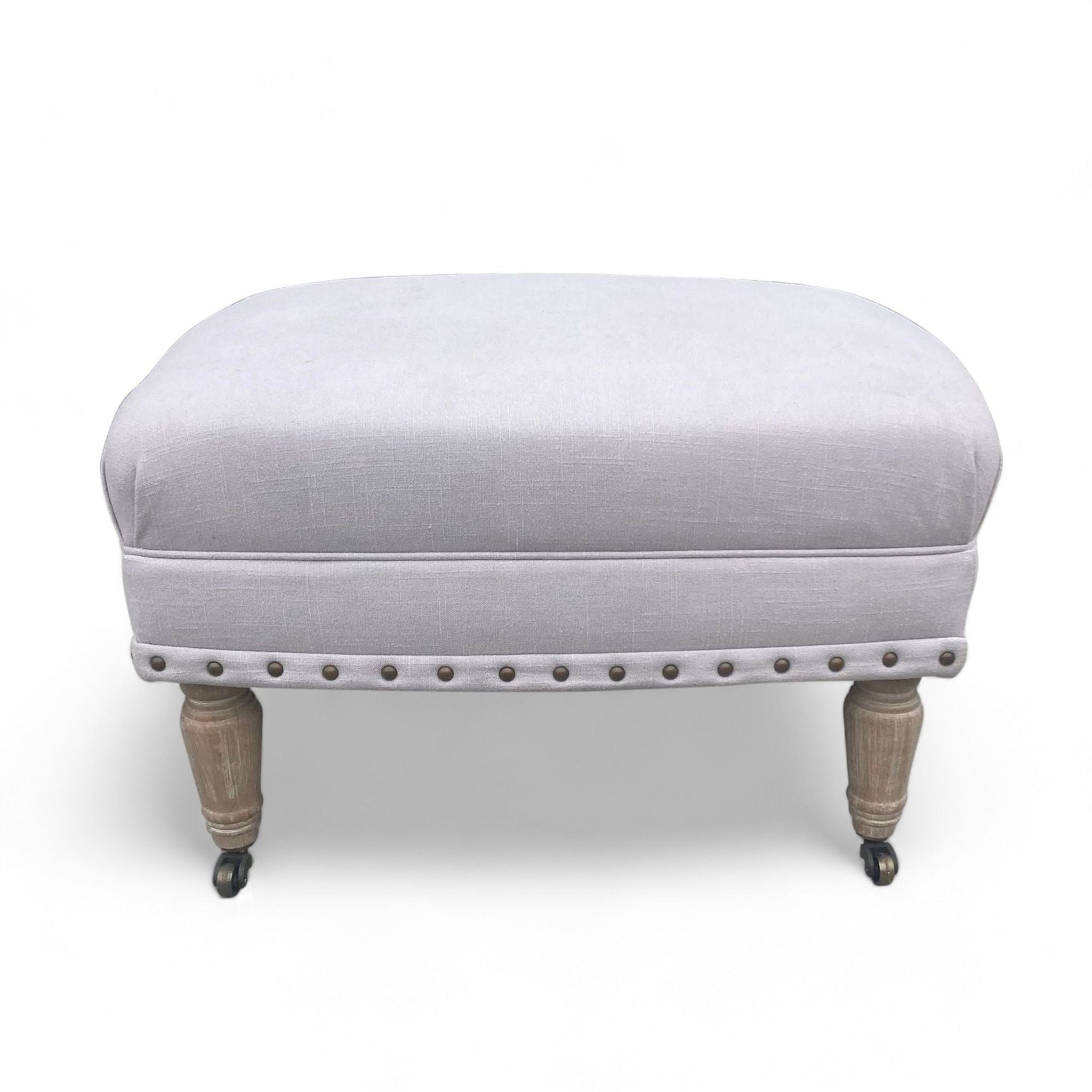 Reperch classic ottoman, light gray upholstery, fluted wooden legs, and nail head detail.
