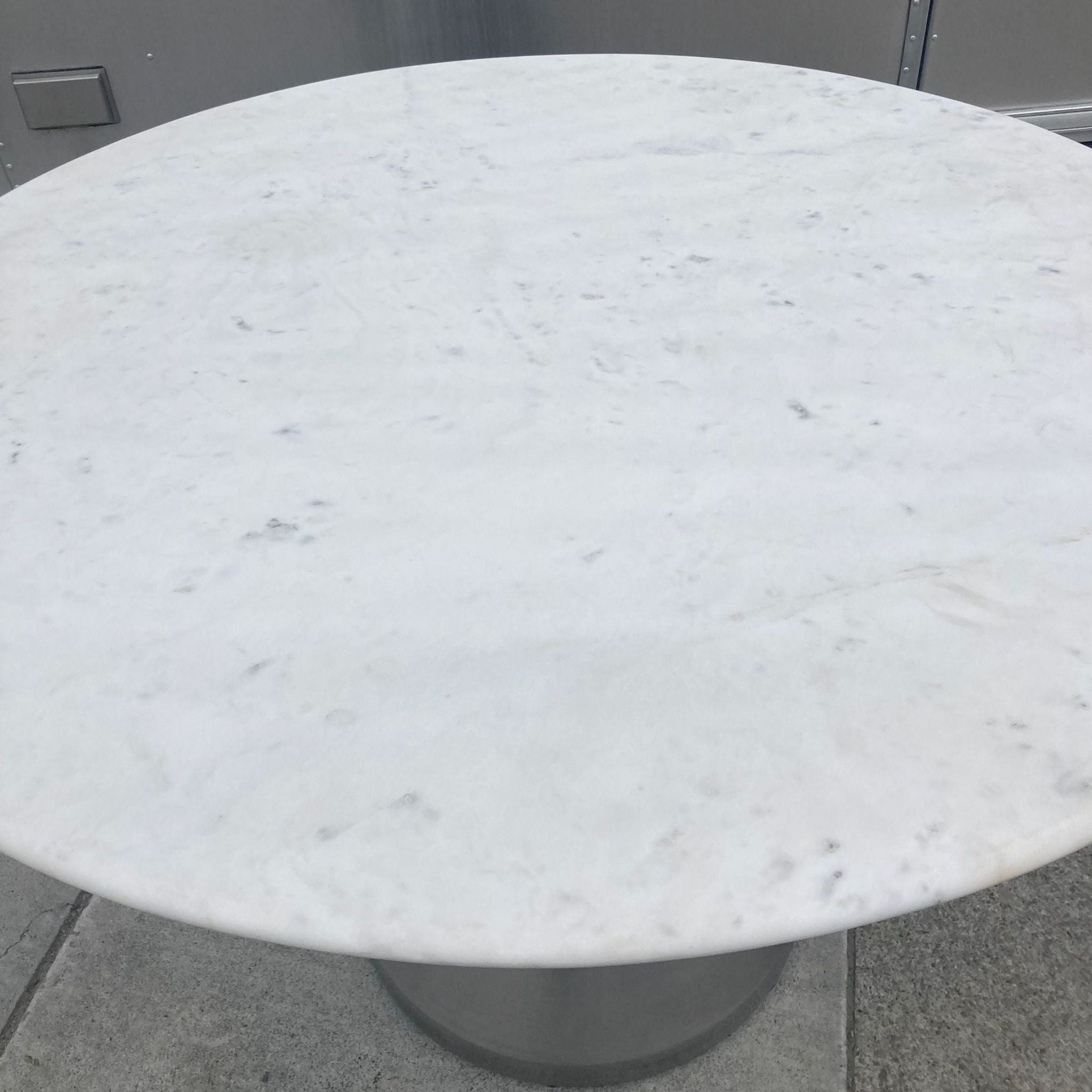 Reperch dining table showcasing marble top and metal base from a high angle.