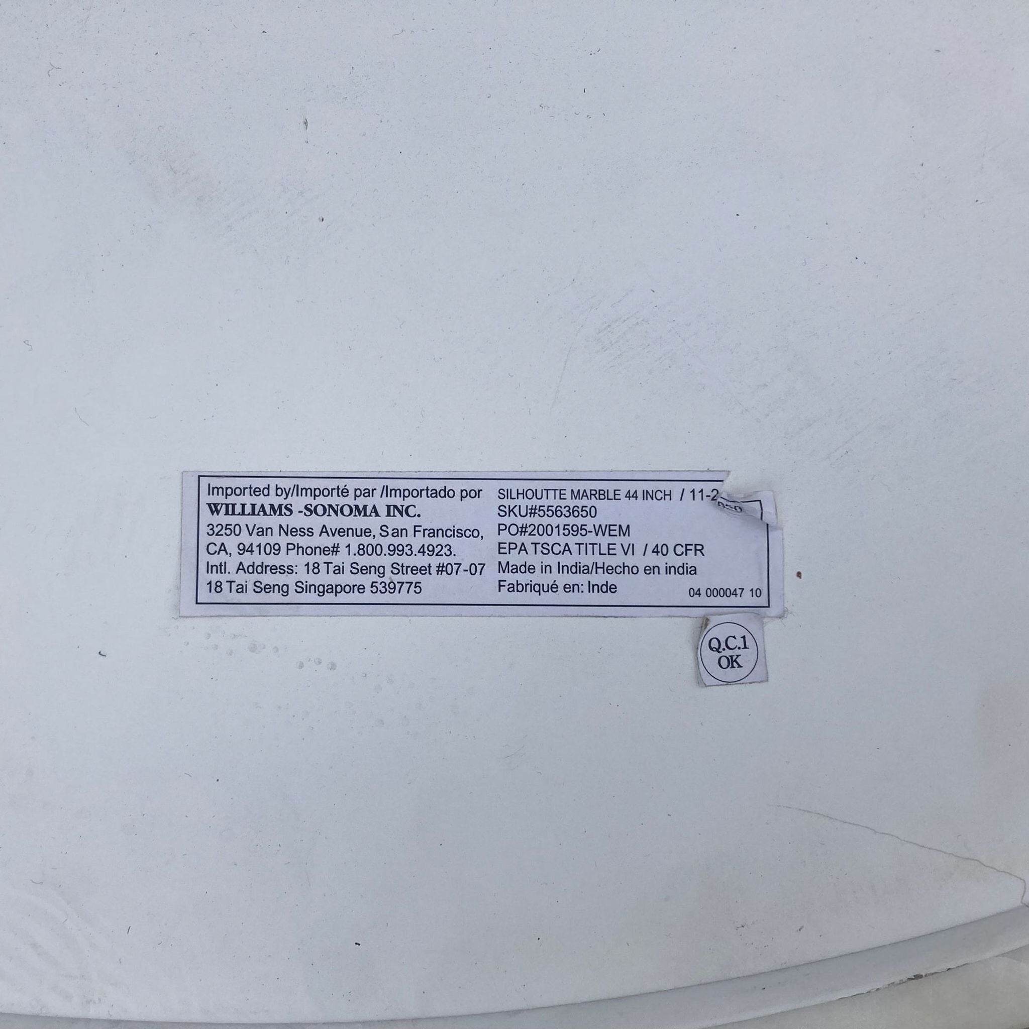 3. "Detailed image showing the import label and product information on the bottom of a Williams Sanoma dining table."