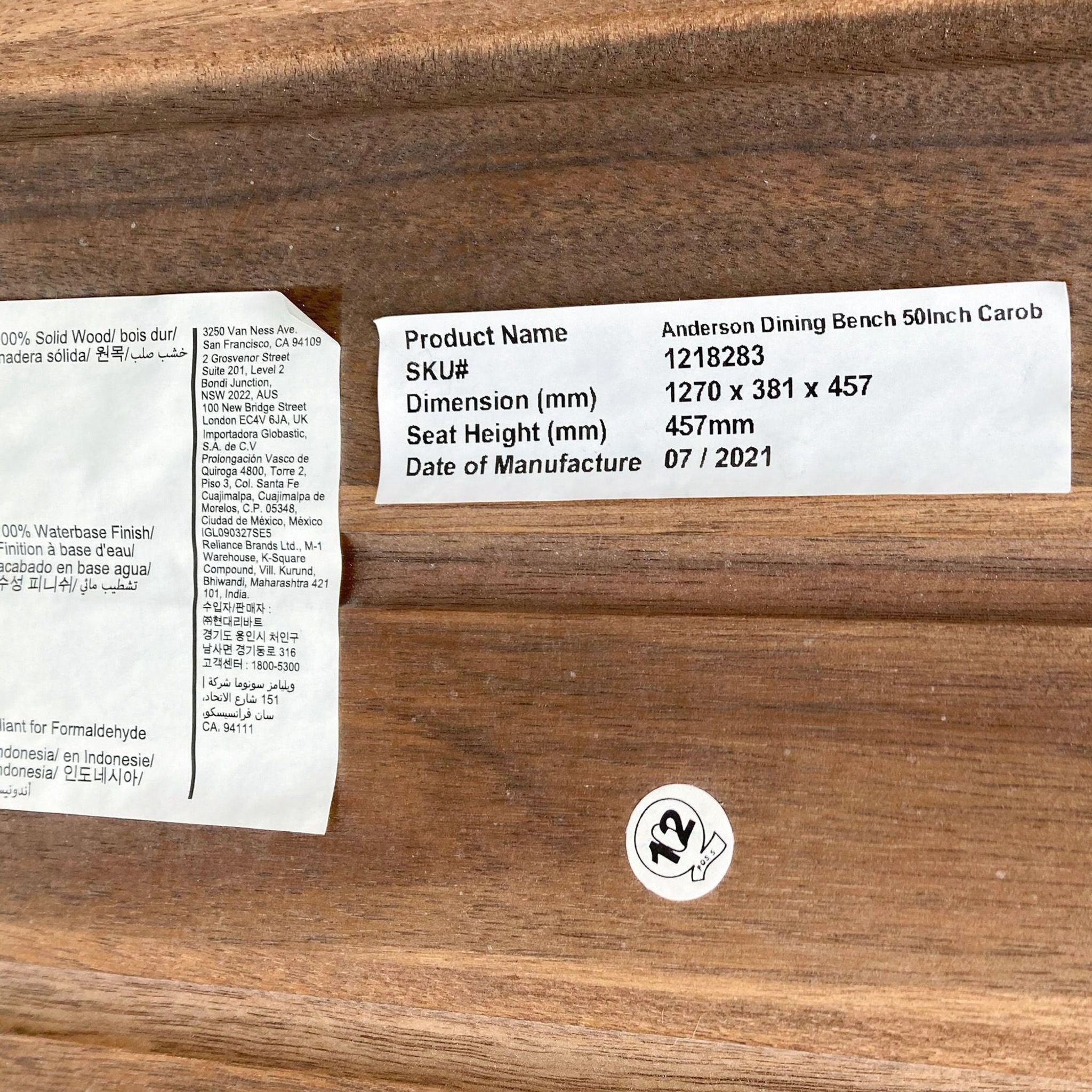 Close-up of product label on Anderson 50" Dining Bench showing SKU, dimensions, and manufacture date.