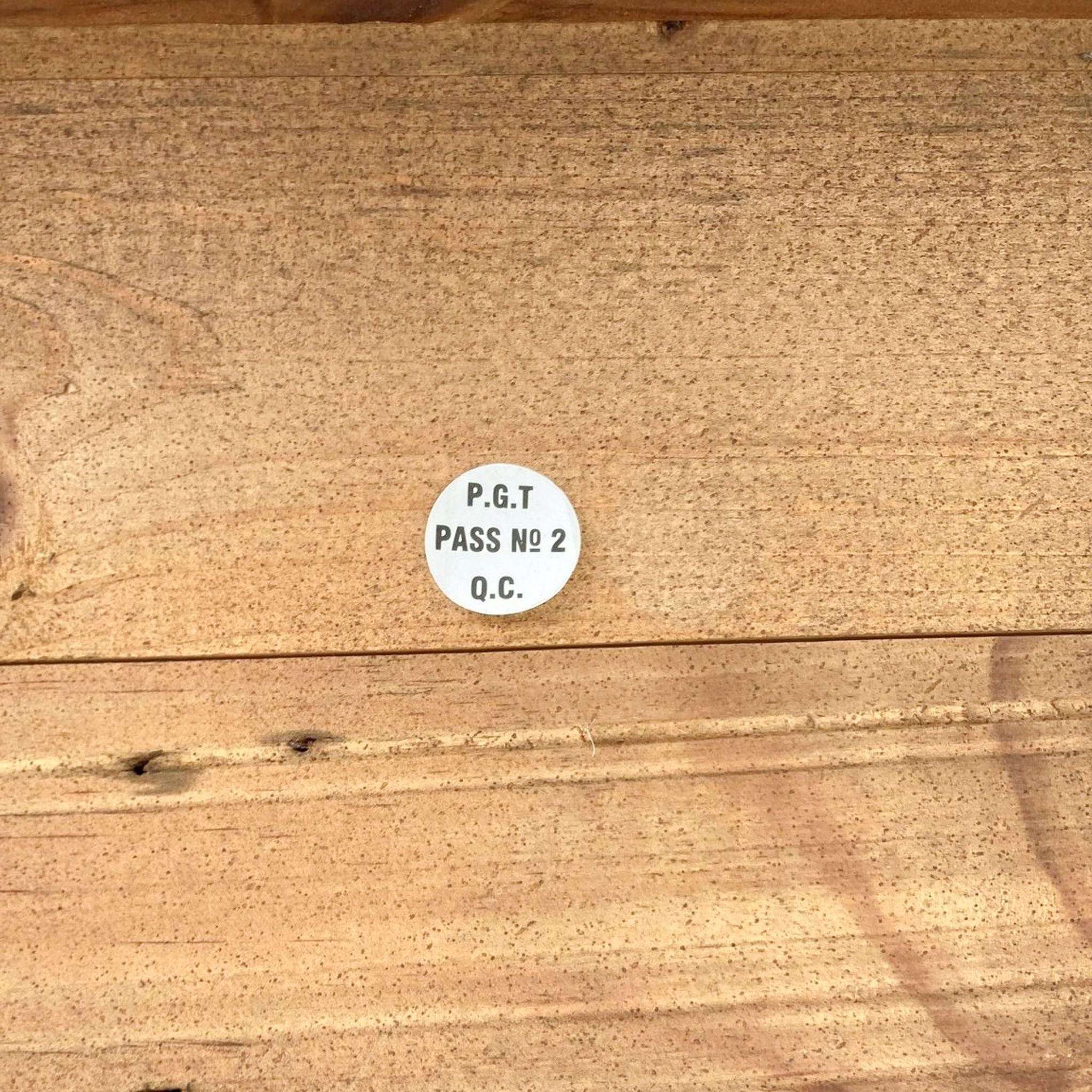 3. Quality control sticker on a rustic wooden bench indicating a passed inspection, with visible wood textures.