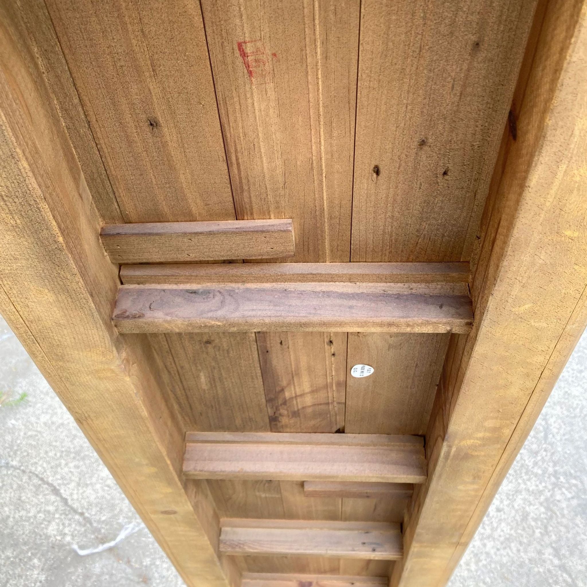 2. Close-up of the underside of a rustic wooden bench showing the simple construction and wood plank details.