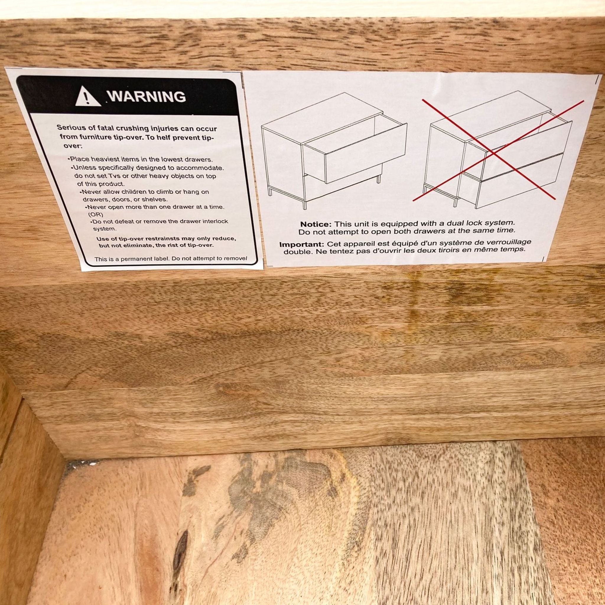 3. "Safety label inside the West Elm filing cabinet warning against tipping and advising on the dual lock system."