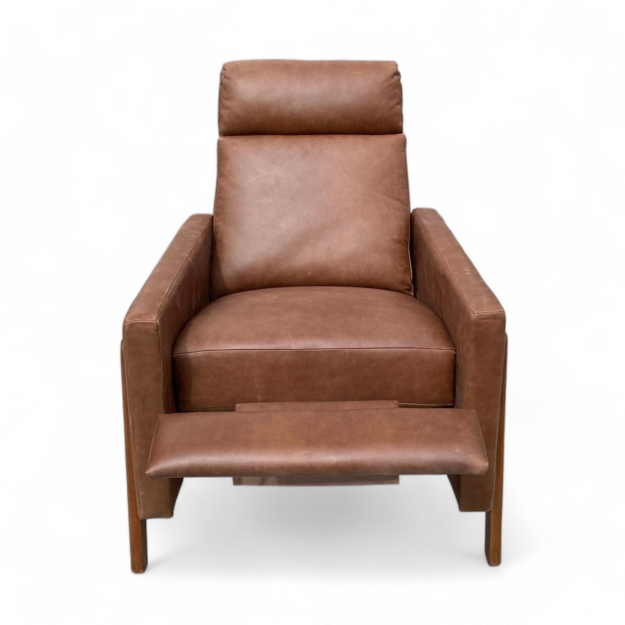 Brown leather Spencer Recliner by West Elm, showcasing a wood frame and push-back mechanism against a clean backdrop.