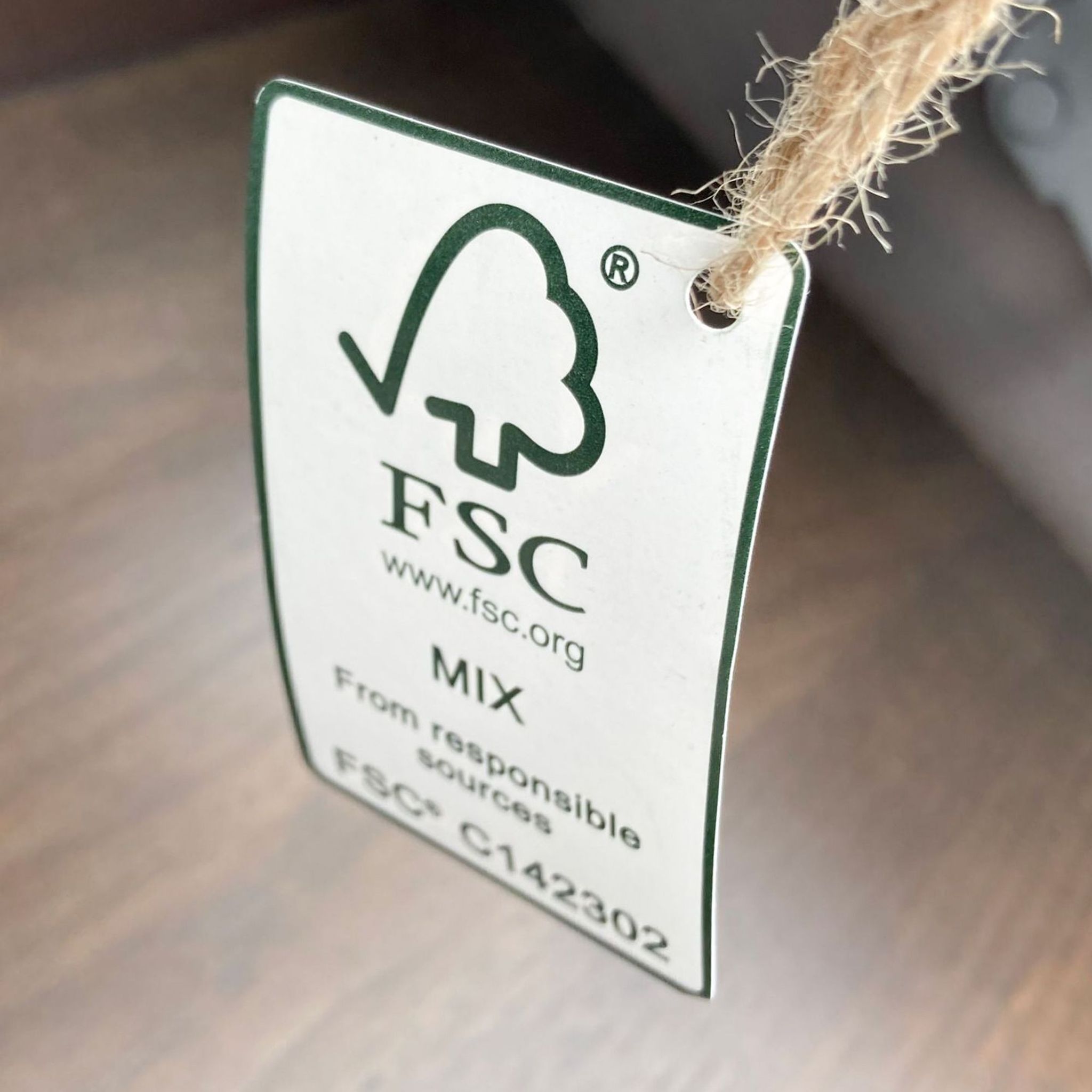 Close-up of a sustainability certification tag from FSC on a West Elm coffee table.