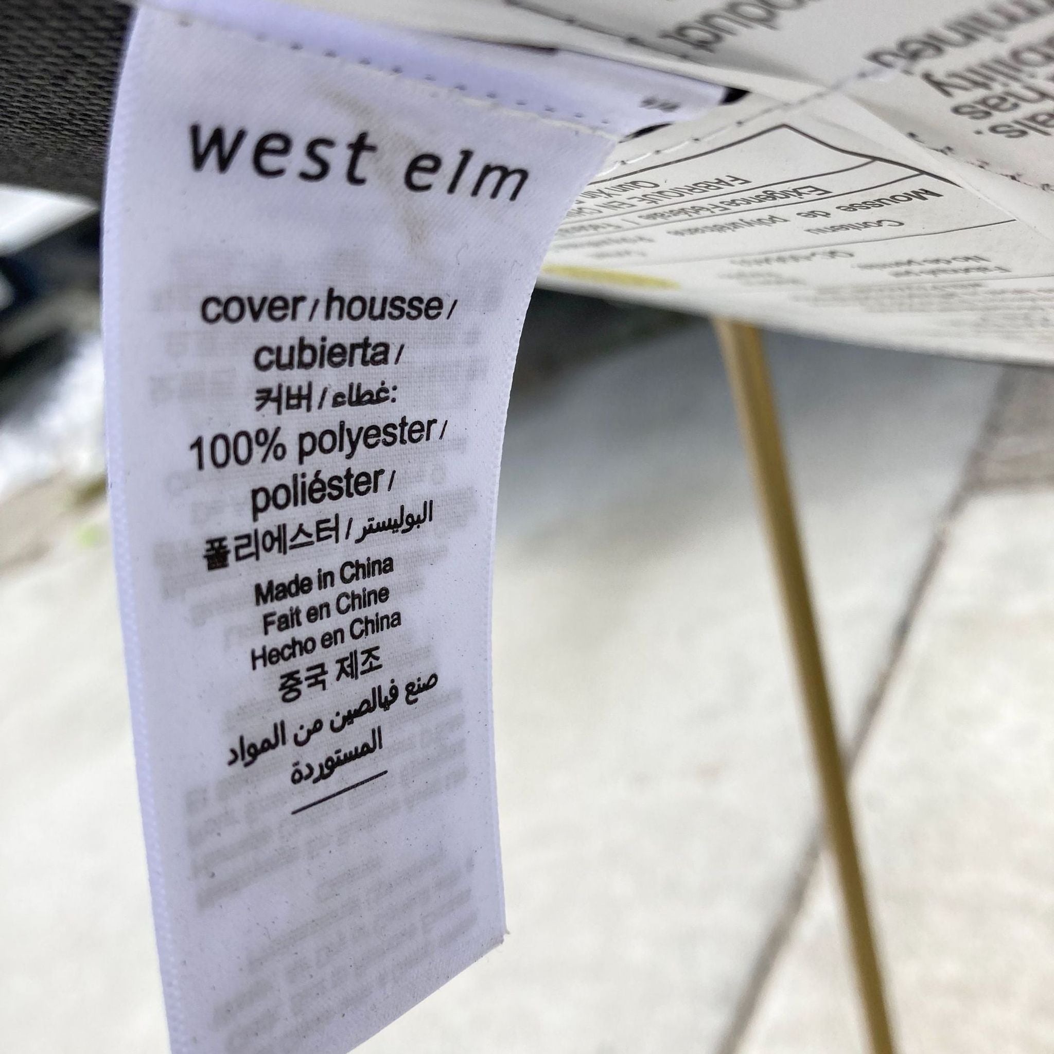 Label from a West Elm Slope dining chair showing material and manufacturing information, multi-language text.