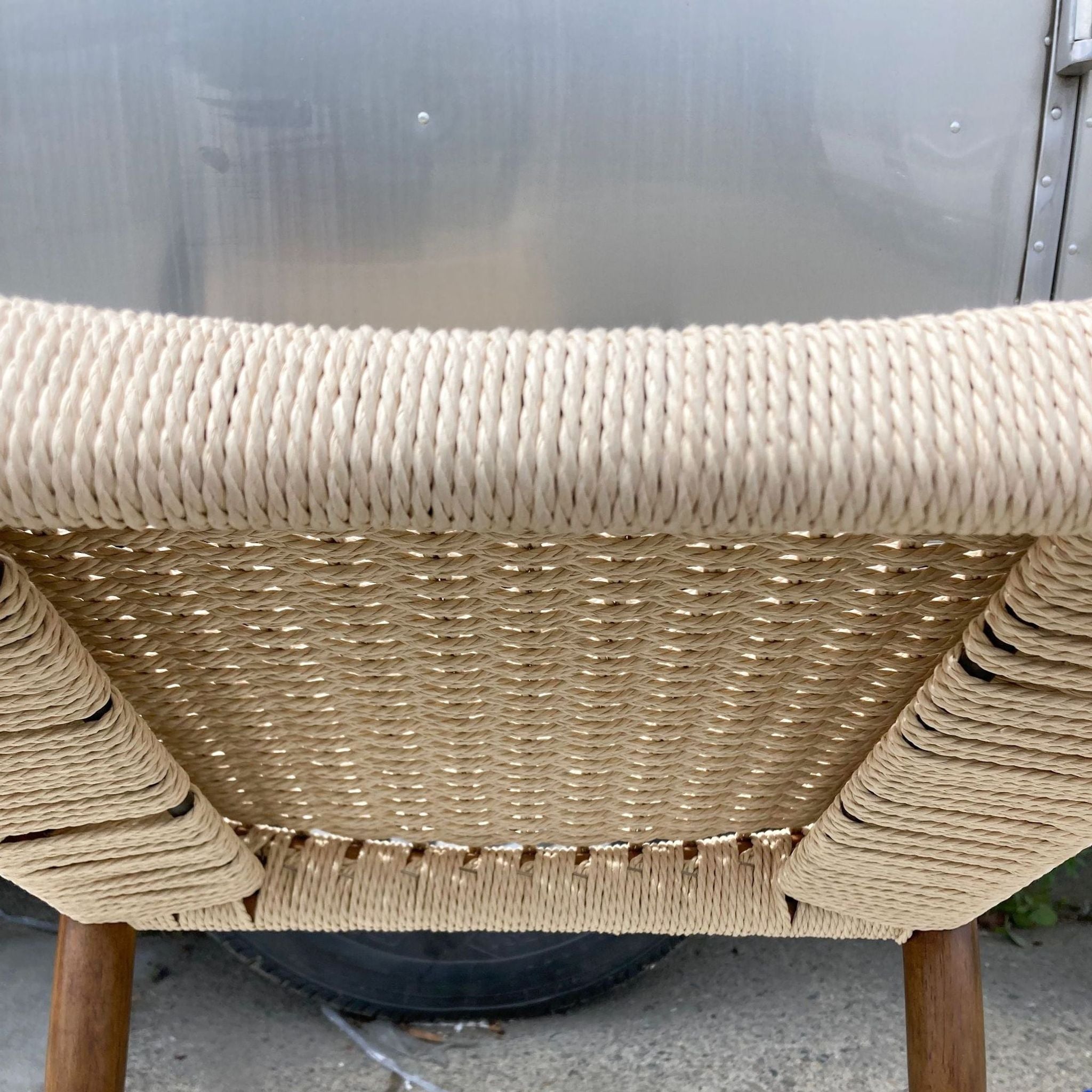 Close-up of West Elm Holland dining chair's seat, highlighting the intricately woven durable cording design and chair's wooden frame.