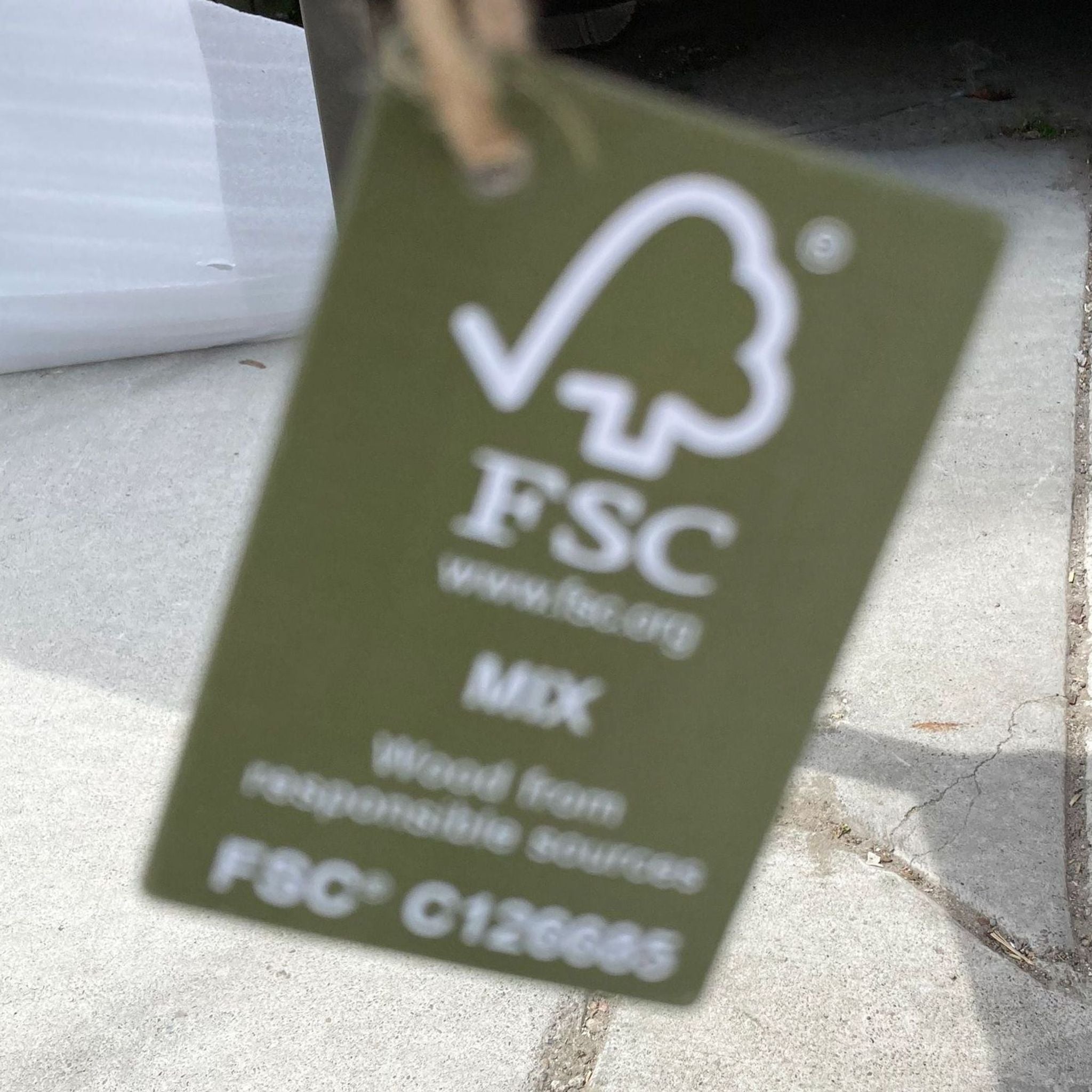 2. "Close-up of a green FSC certification tag indicating responsible wood sourcing for furniture."