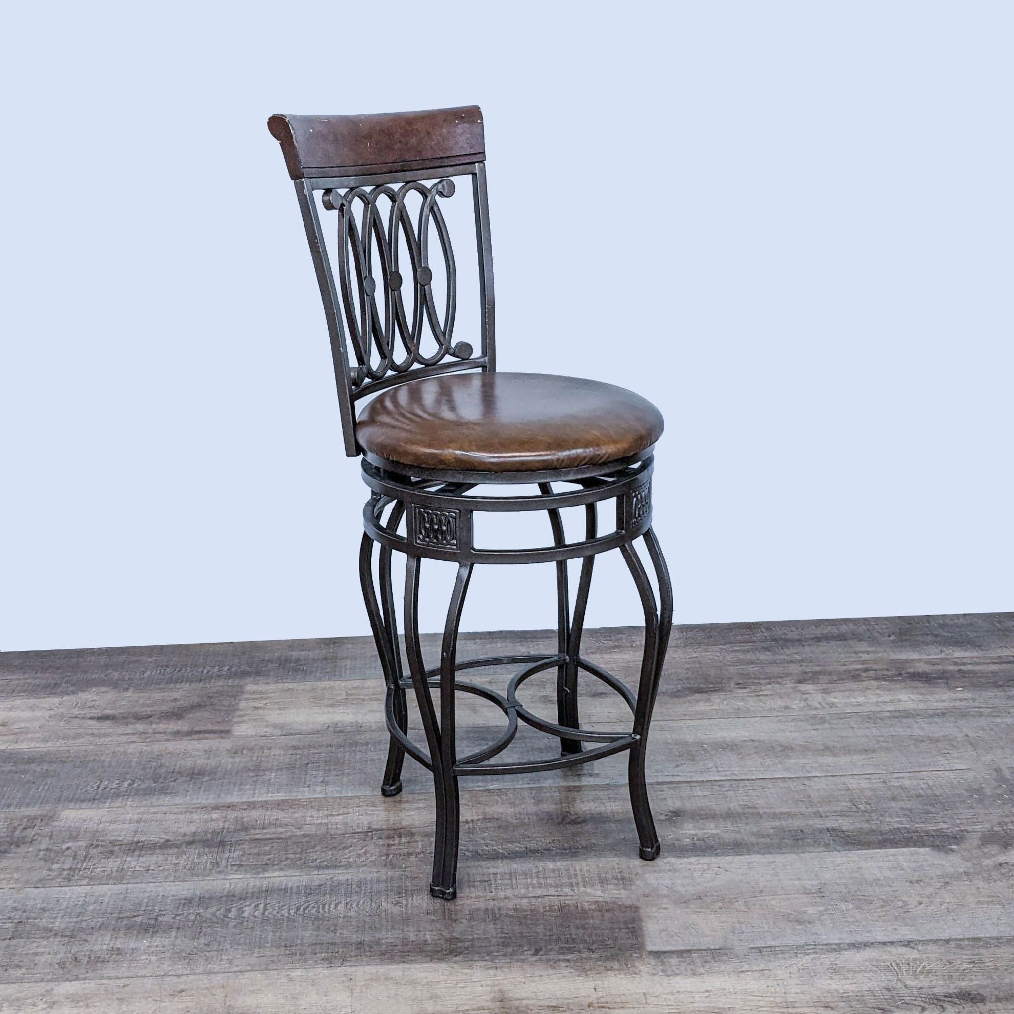 Elegant metal swivel barstool with cushioned seat and wood backrest by Reperch, on a wooden surface.