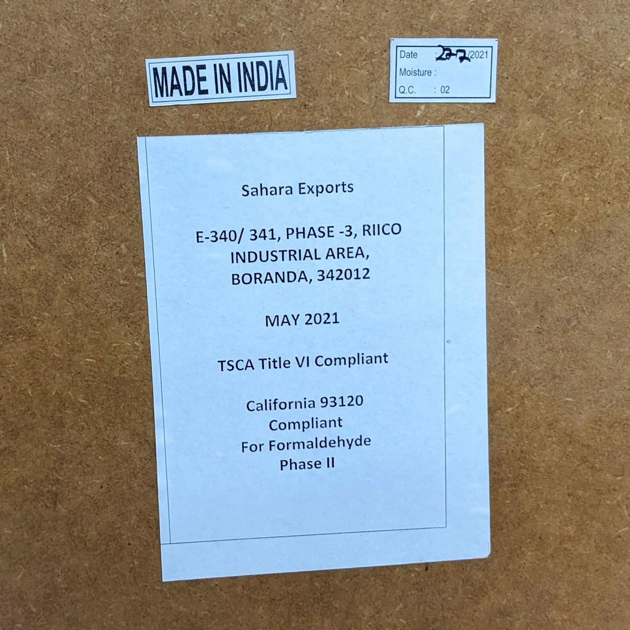 3. "Label on the underside of a Pottery Barn coffee table indicating 'Made in India,' with manufacturer details and compliance info."