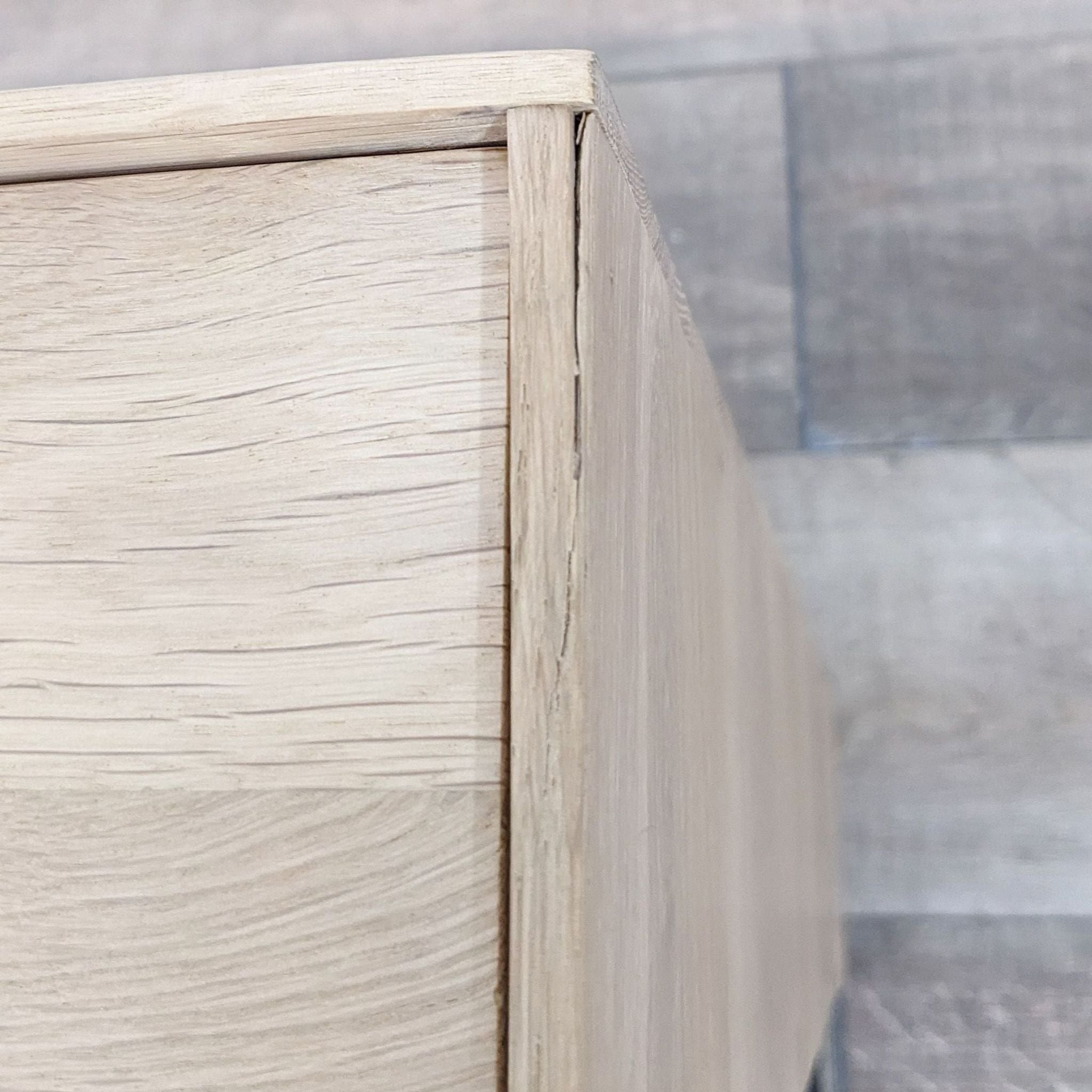 3. Close-up of the corner of an Industry West coffee table, highlighting the wood grain and joinery details on a wood-textured floor.