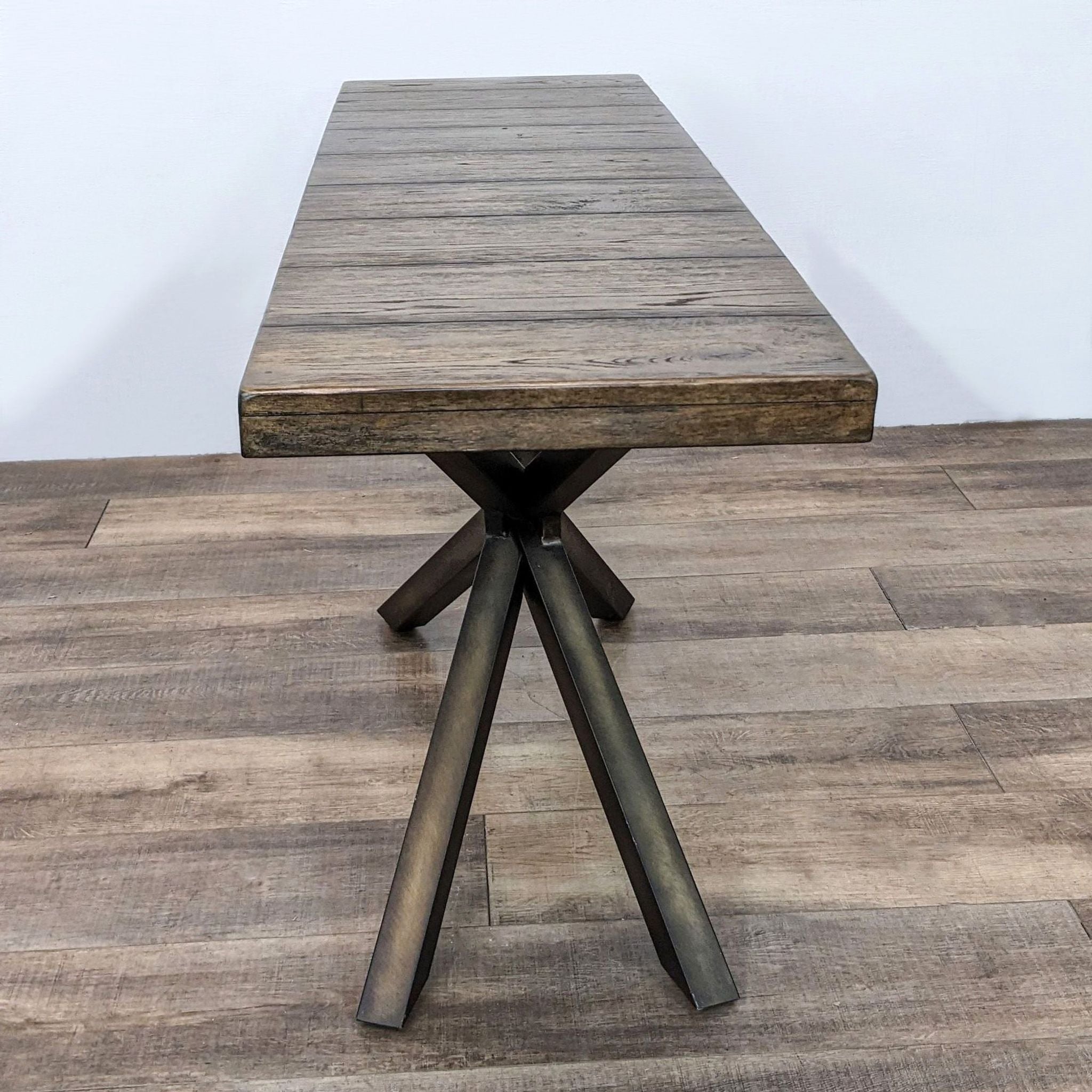 Pottery Barn side table with reclaimed wood top and double cross metal legs, displayed on a wooden floor.