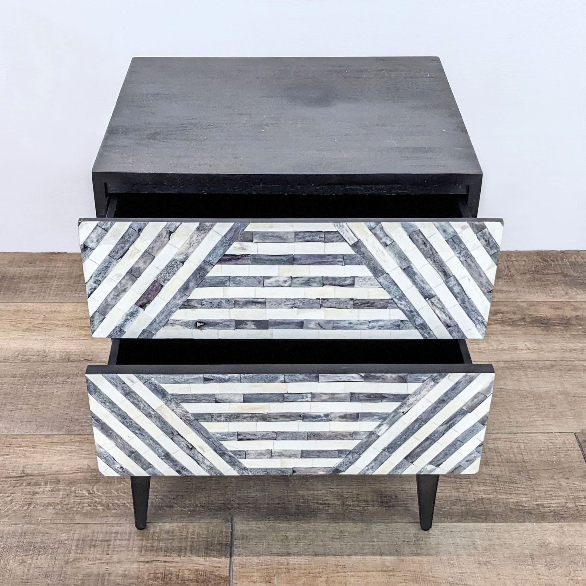 2. Front view of a West Elm end table with herringbone-like striped drawers, on a wooden floor.