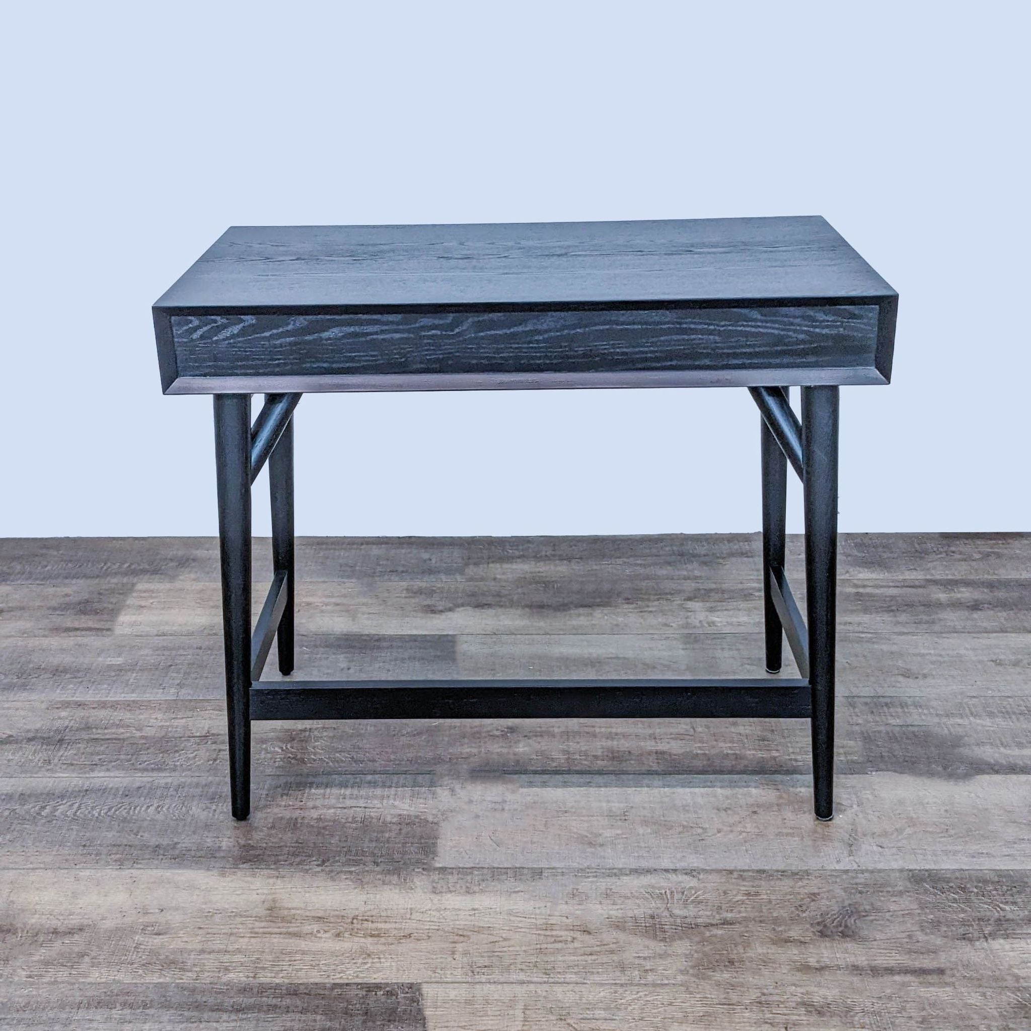 Stylish 36" West Elm desk in black, featuring a drawer and sleek metal pulls, displayed against a wooden floor backdrop.