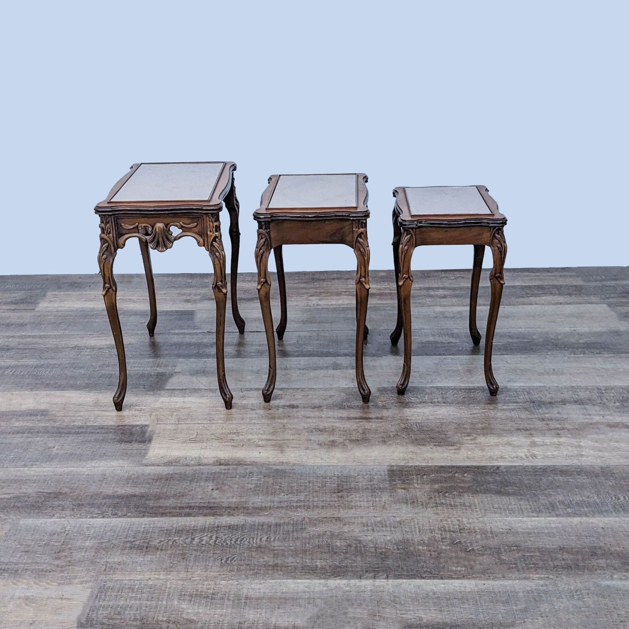 Set of three Reperch end tables with glass covers and detailed wooden legs, displayed in a row.