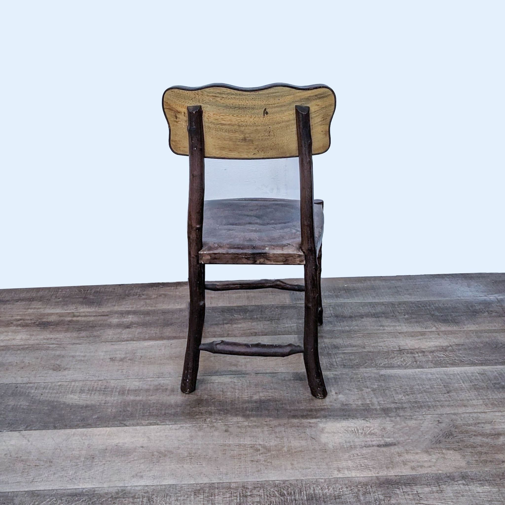 3. "A single chair from the Reperch 7-piece dining set, with a rustic Saman wood frame and a comfortably contoured leather seat."
