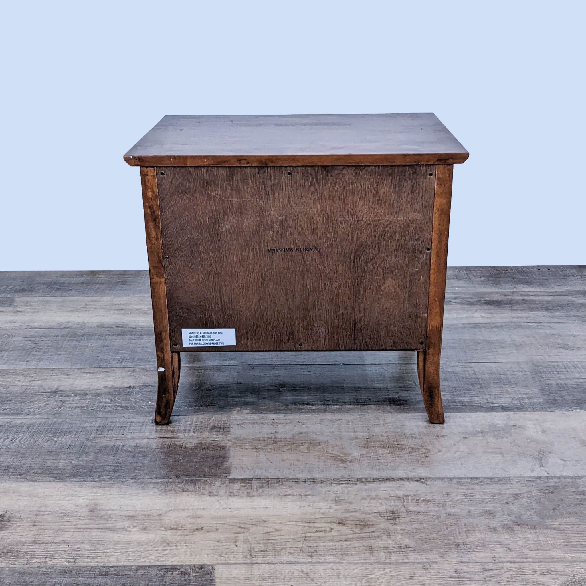 Back view of a Reperch end table with a label, showcasing craftsmanship, against a neutral backdrop.