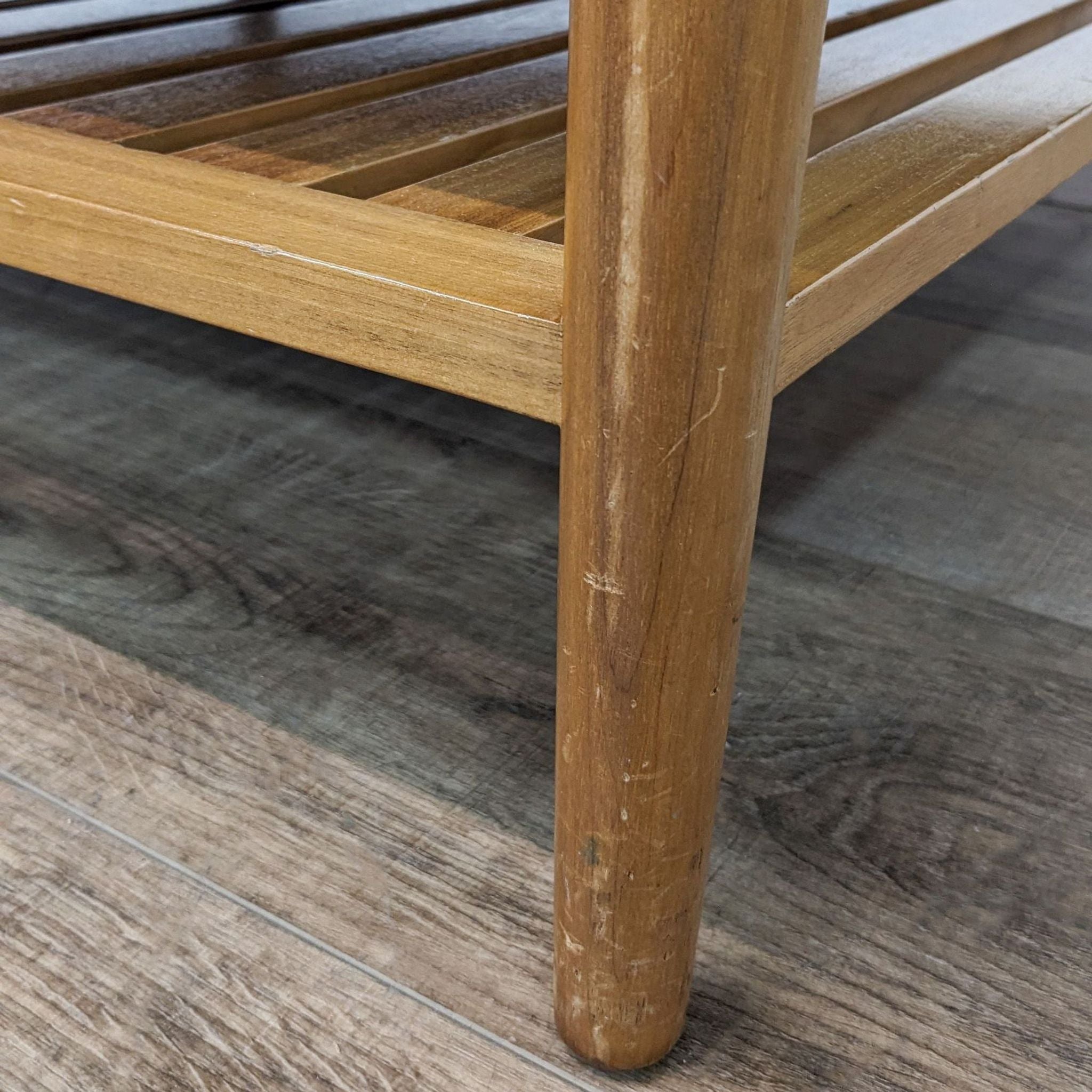 Alt text 3: Detailed view of the wooden frame and shelf of a Reperch leatherette ottoman, displaying the sturdy structure and wood grain texture.