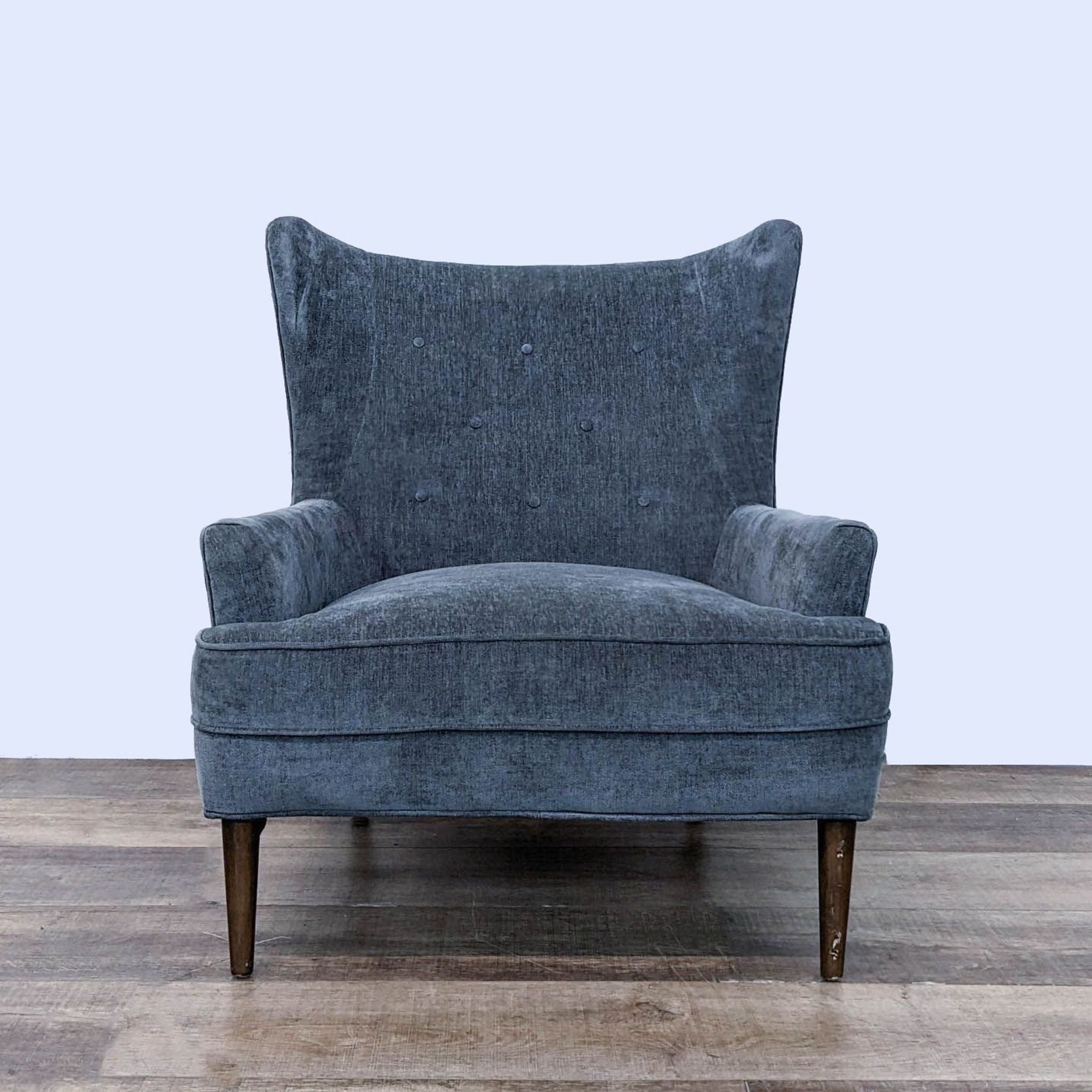 a pair of blue velvet wingback chairs