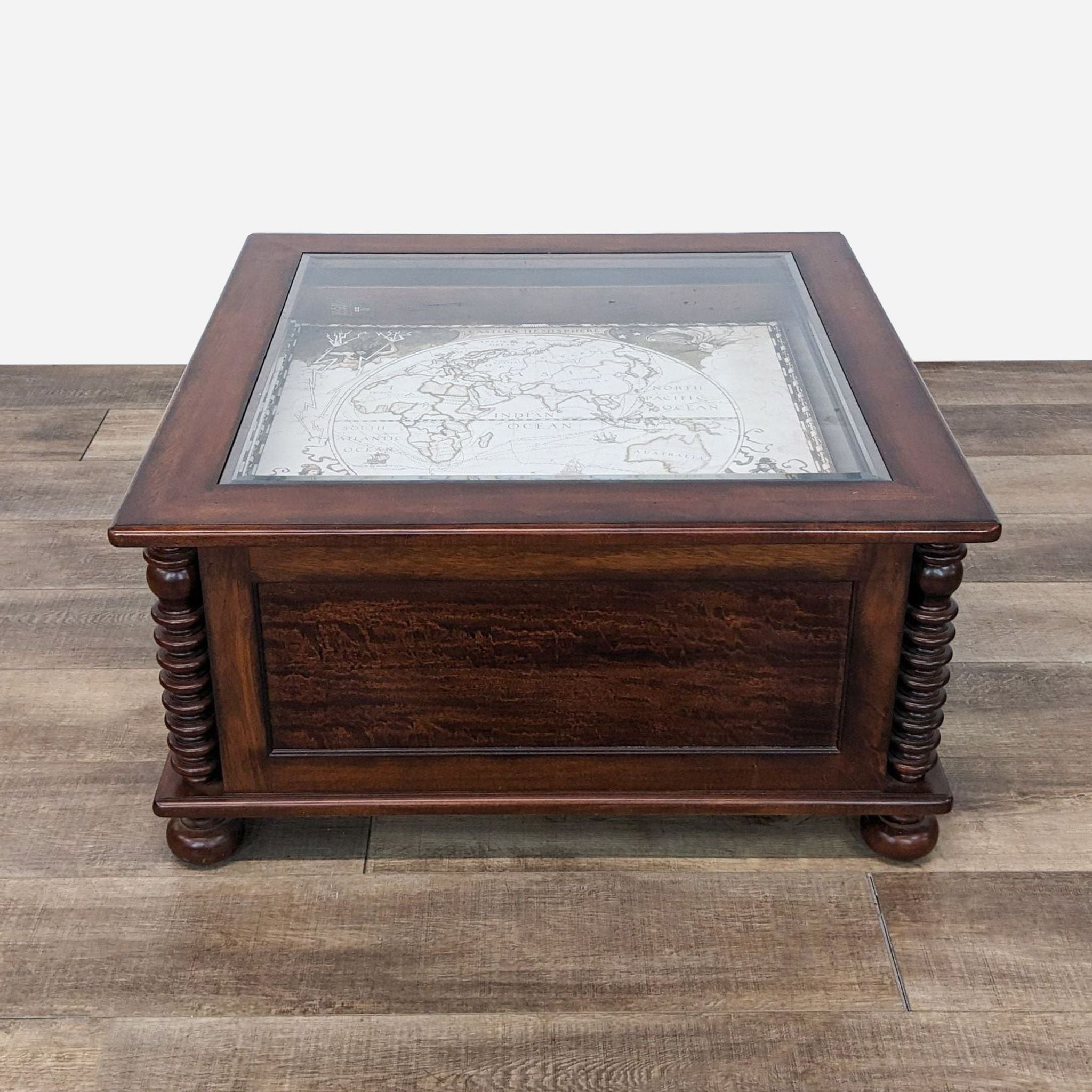 a vintage map table with a glass top.