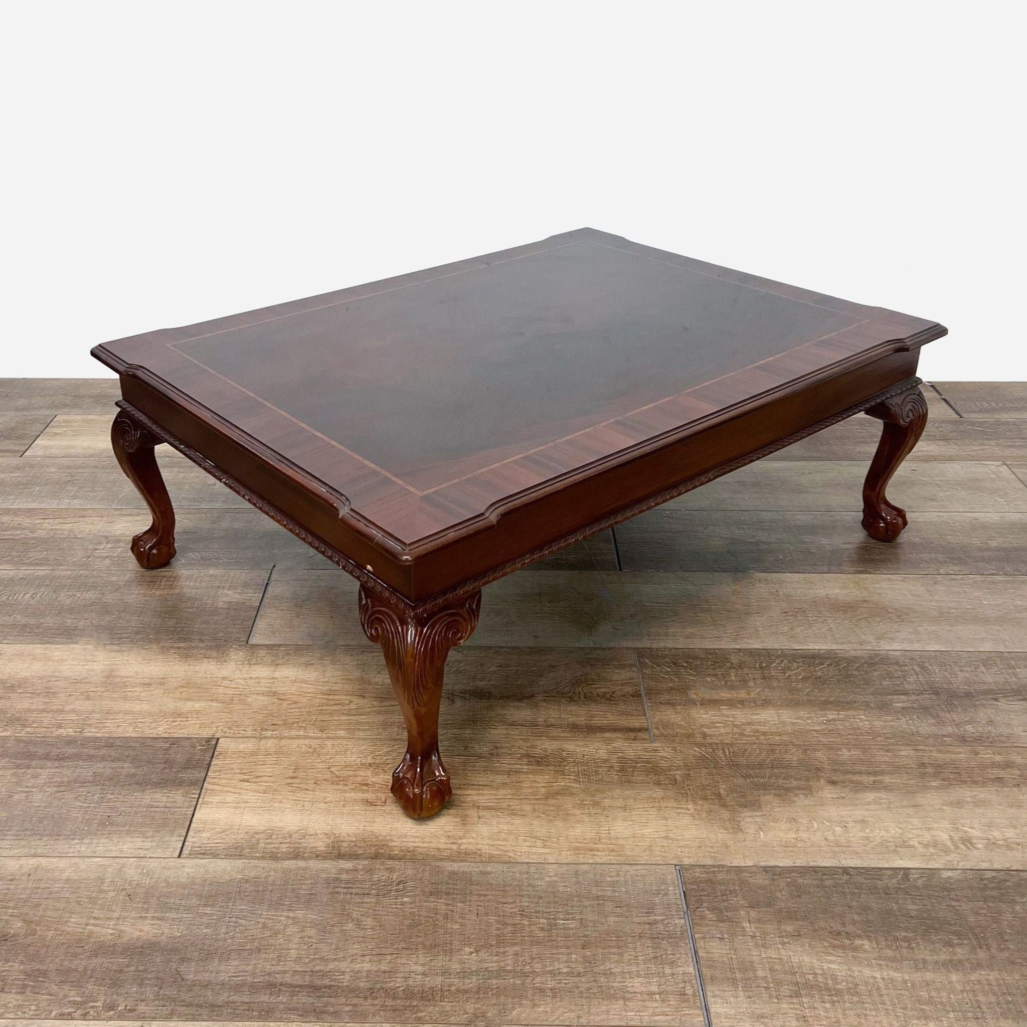 a mahogany coffee table with a mahogany top and a matching footstool.