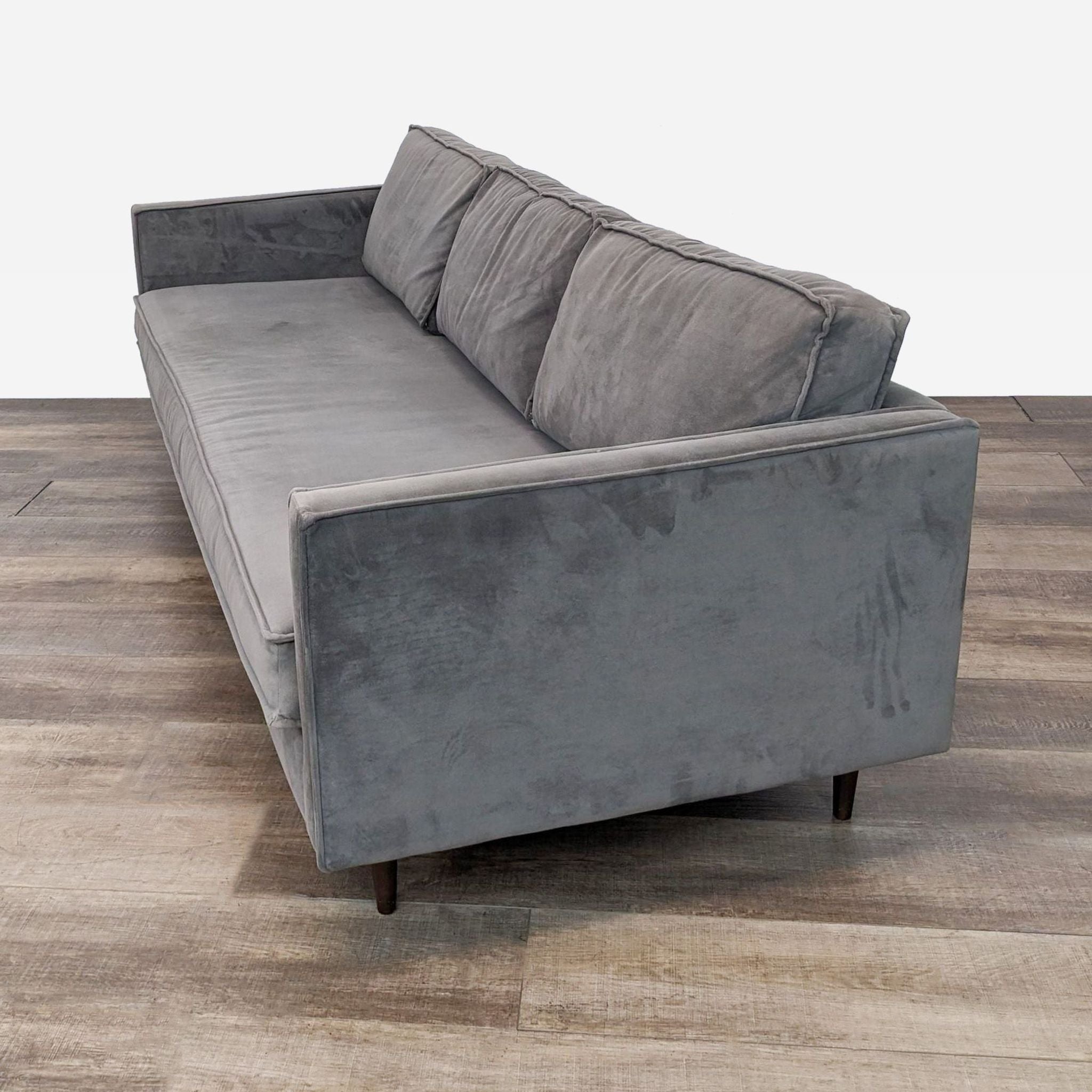 sofa is a modern sofa that is made of a soft grey velvet fabric. the sofa is made