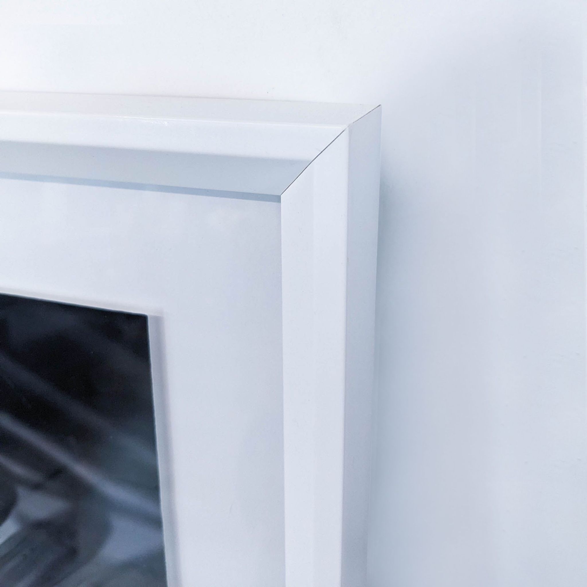 a large white painted wood fireplace with a glass top and a white painted finish.