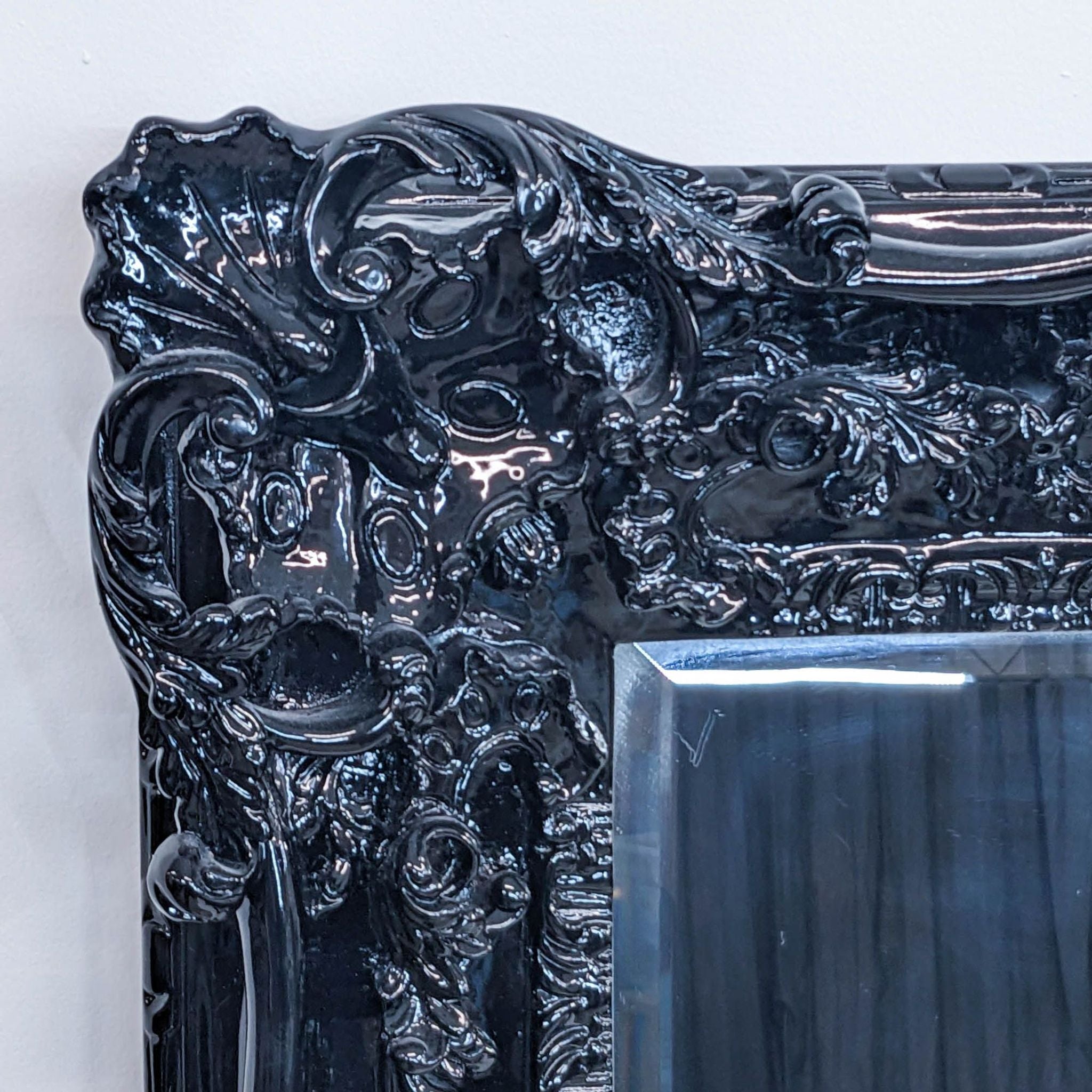 a large black and white mirror with a floral design