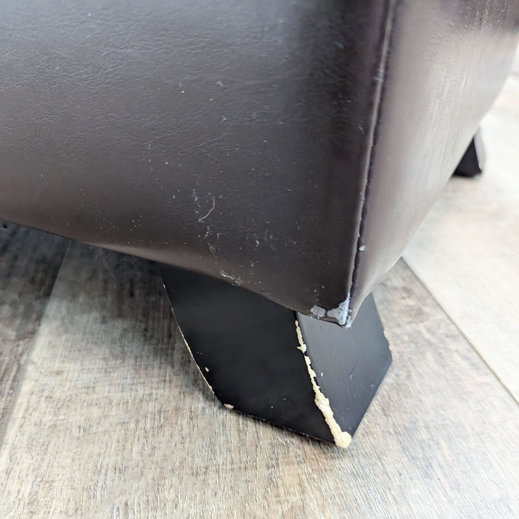 a close up of a leather chair with a black leather base.