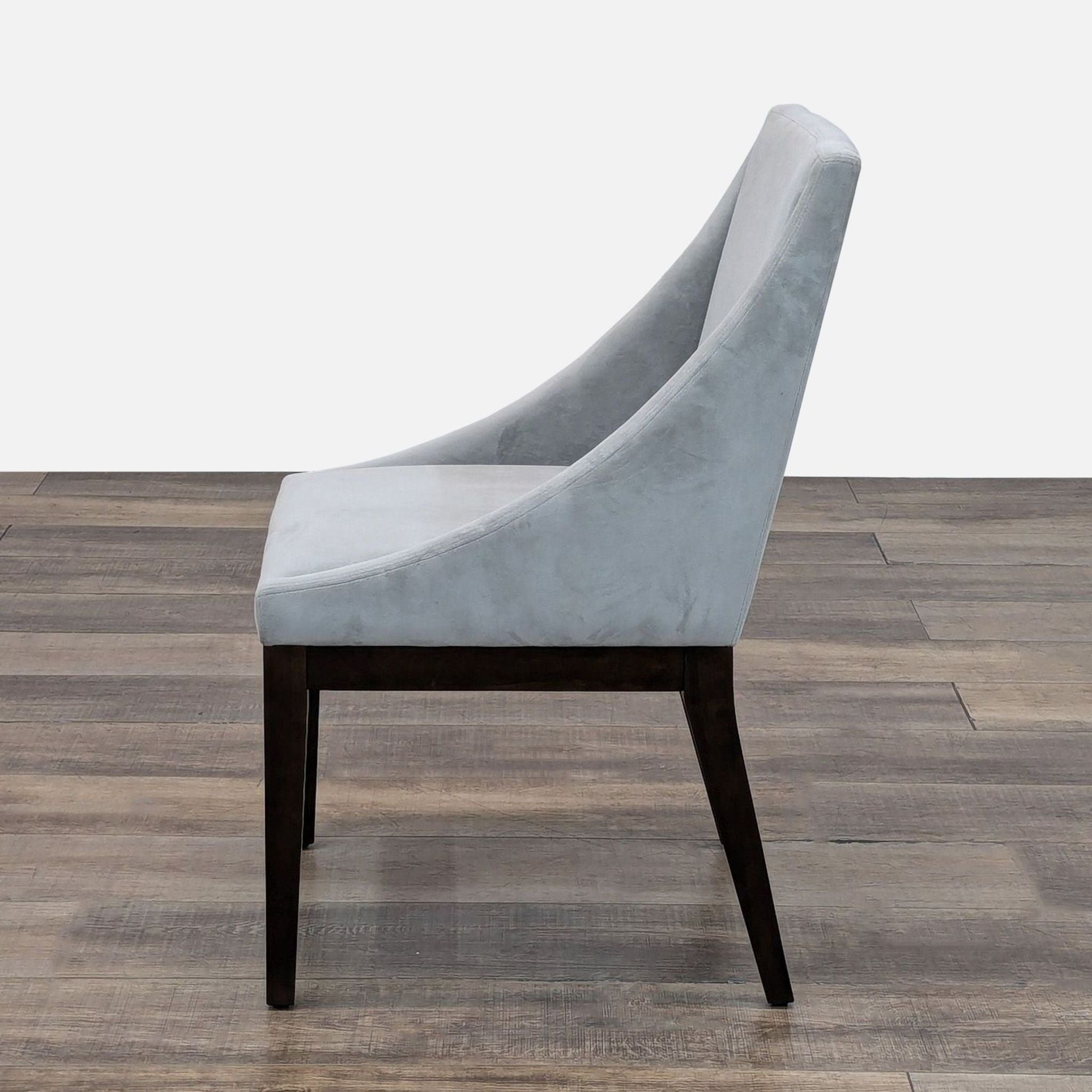 Gray fabric chair with dark wood legs, shown from the side, by West Elm.