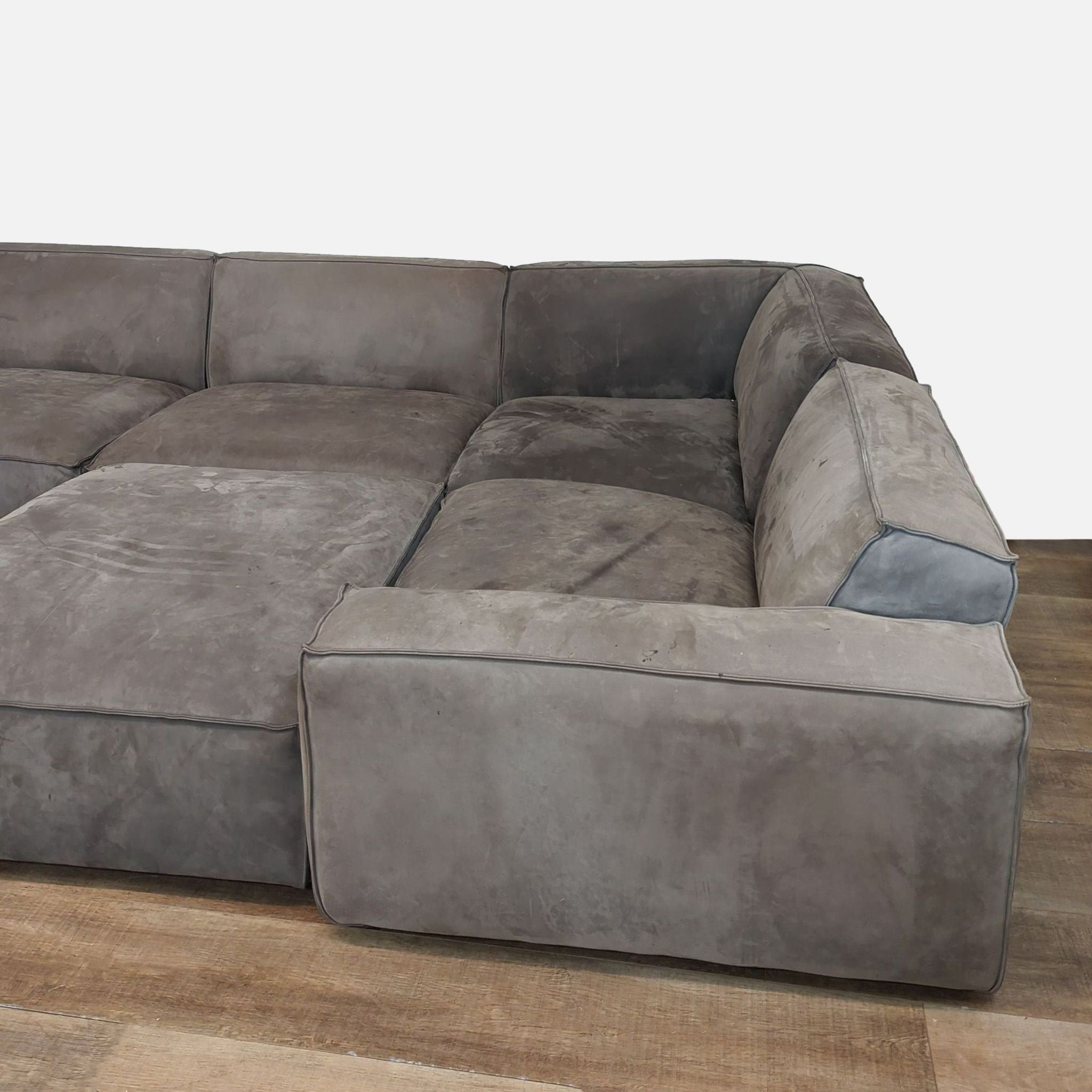 Luxurious sectional sofa with padded seats and back, placed on wood floor.