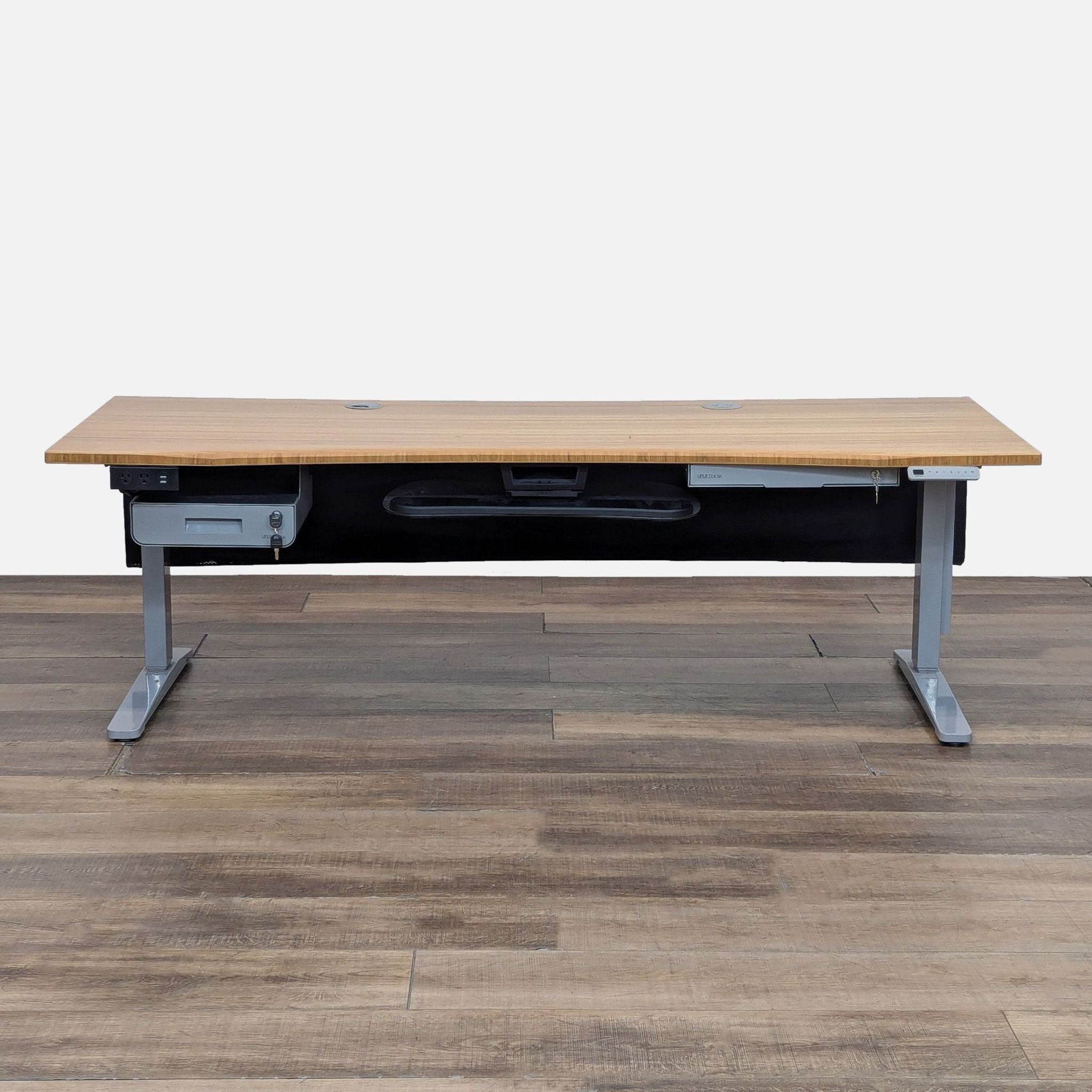 UPLIFT Desk with bamboo top, programmable height, and lockable money drawer.