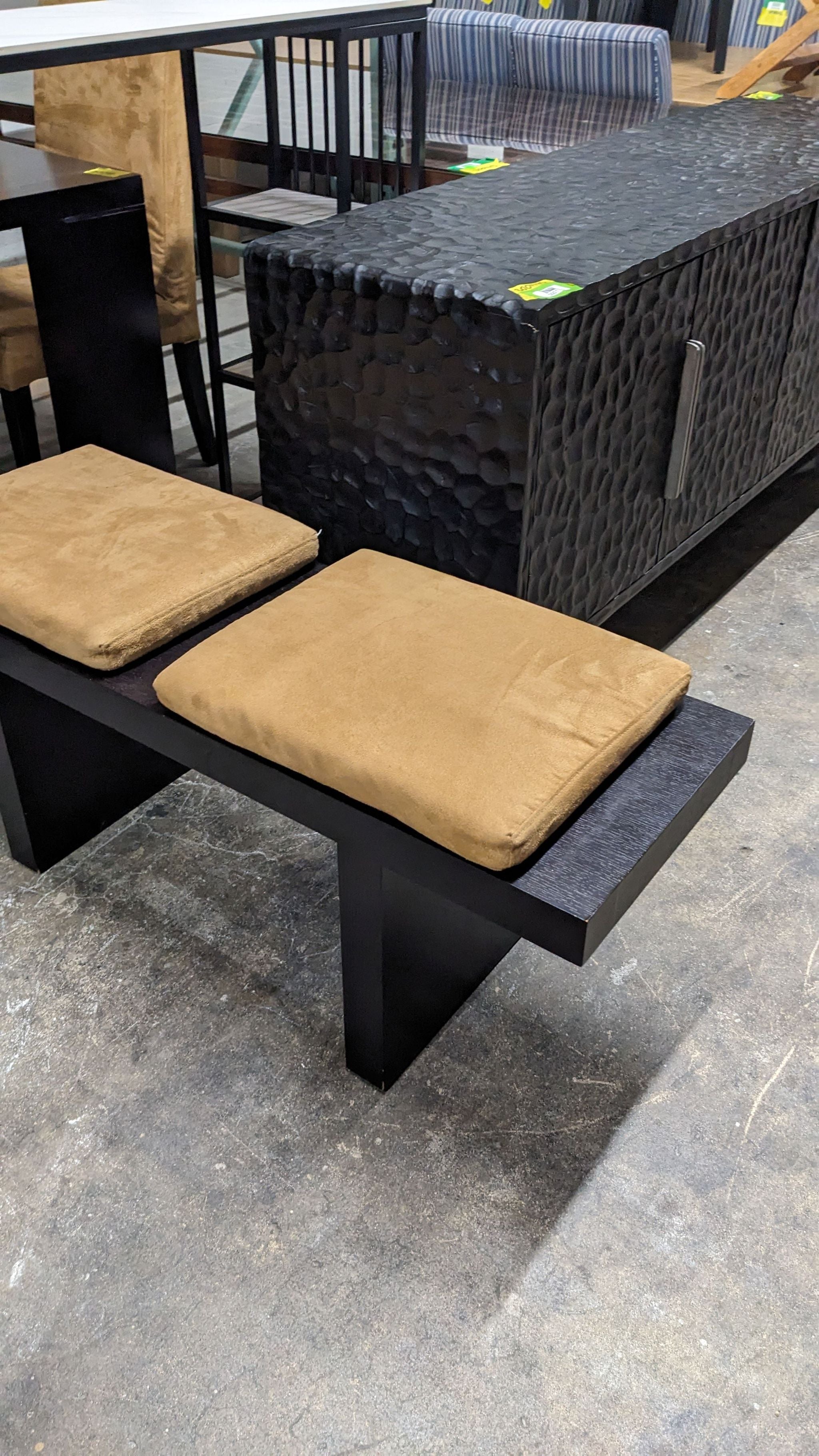 Alt text 2: Black Reperch bench featuring two plush tan seat pads, set against a store backdrop with various furniture items.