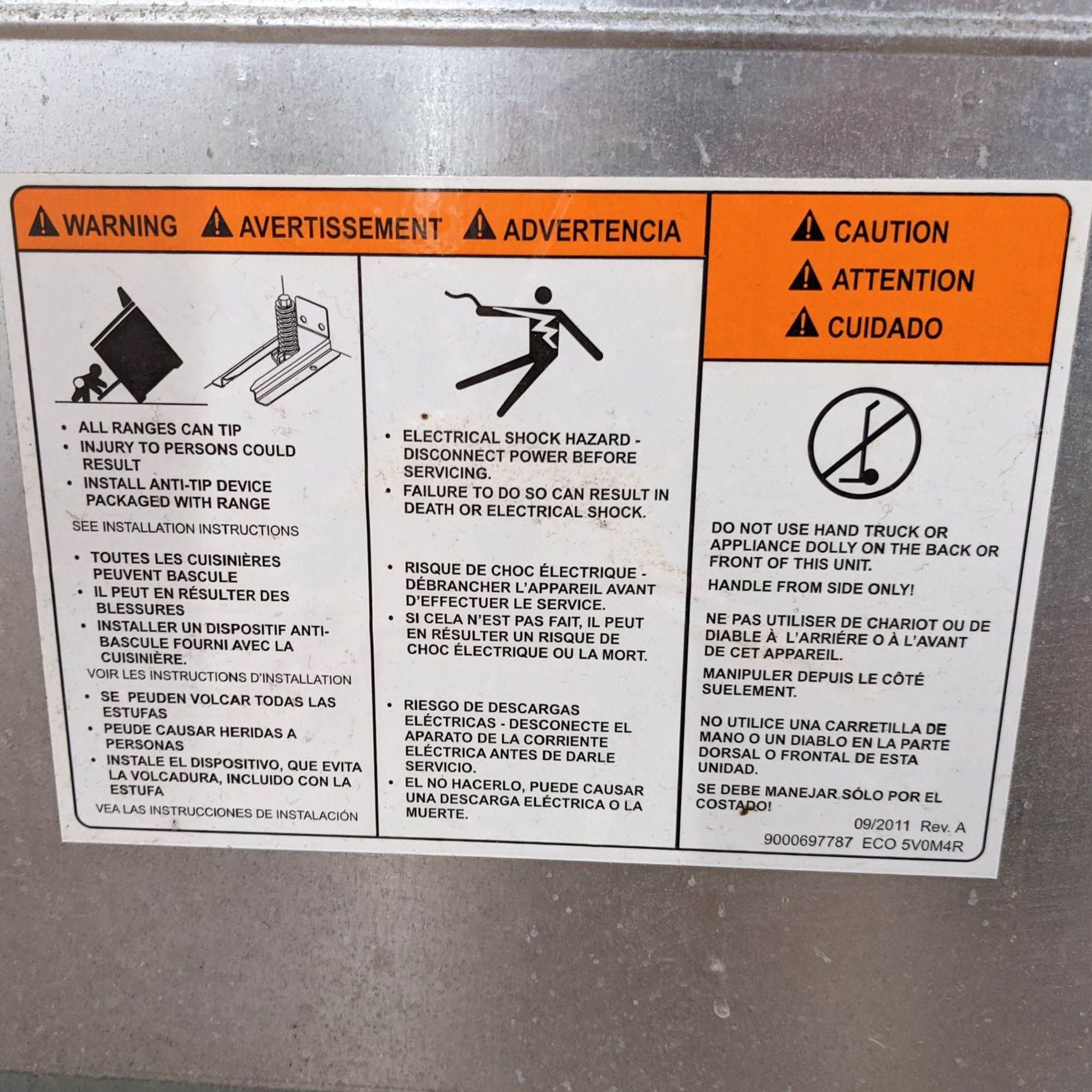 3. Close-up of warning and caution labels on a Thermador stove in English, French, and Spanish, advising against tipping and electrical hazards.