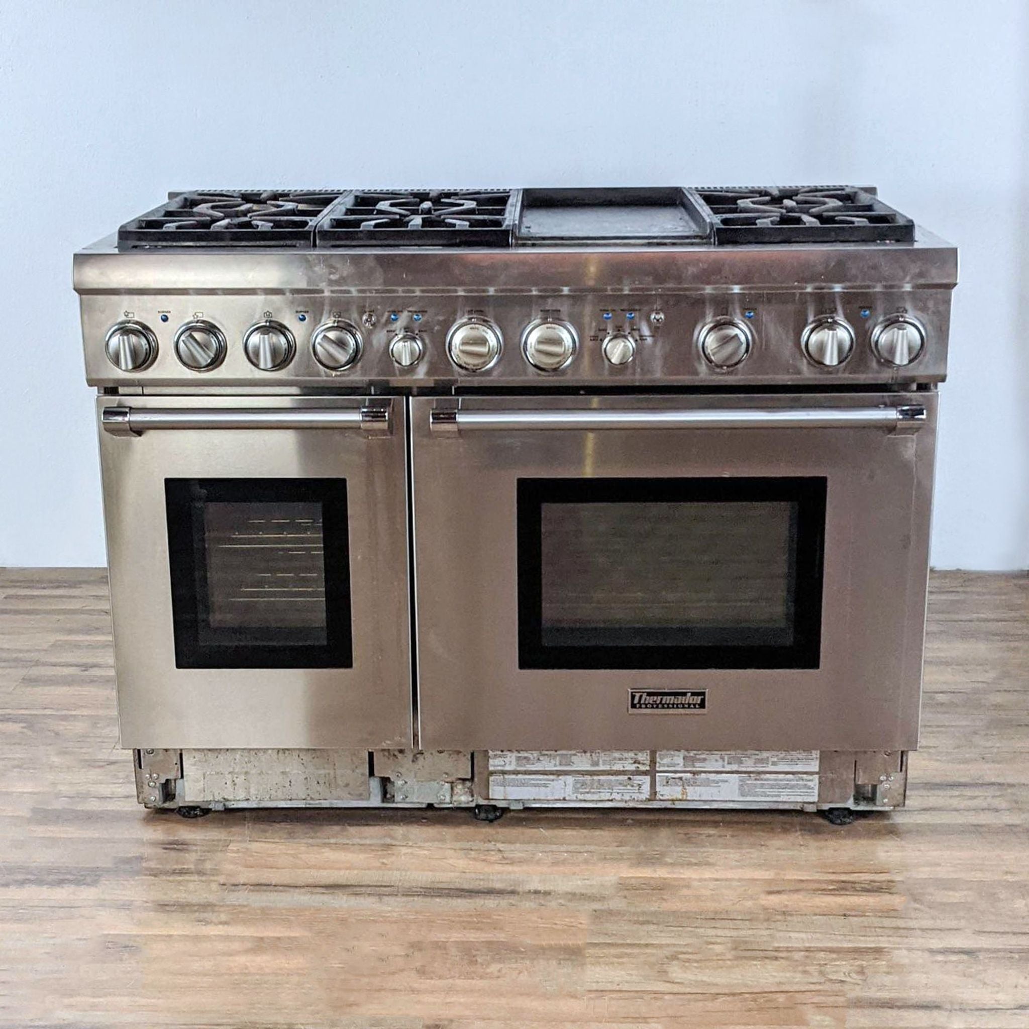 1. Stainless steel Thermador professional stove and oven combo with gas cooktop and dual ovens, displayed on a hardwood floor.