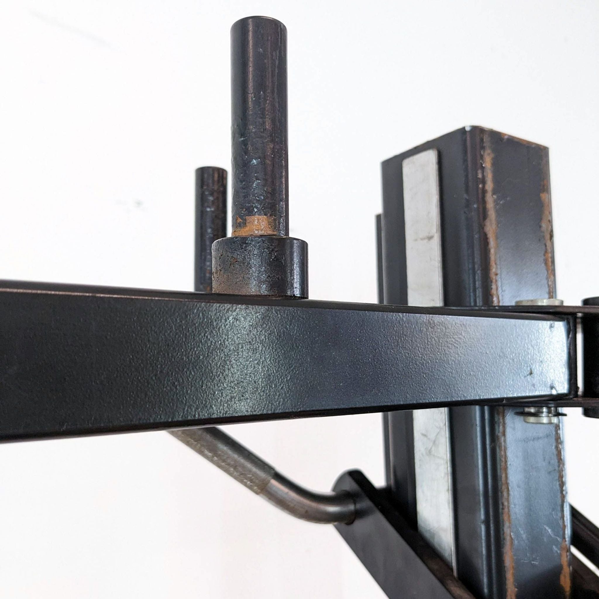 Alt text 2: Close-up of a Soloflex gym equipment's resistance arm and weight pegs showing signs of use.
