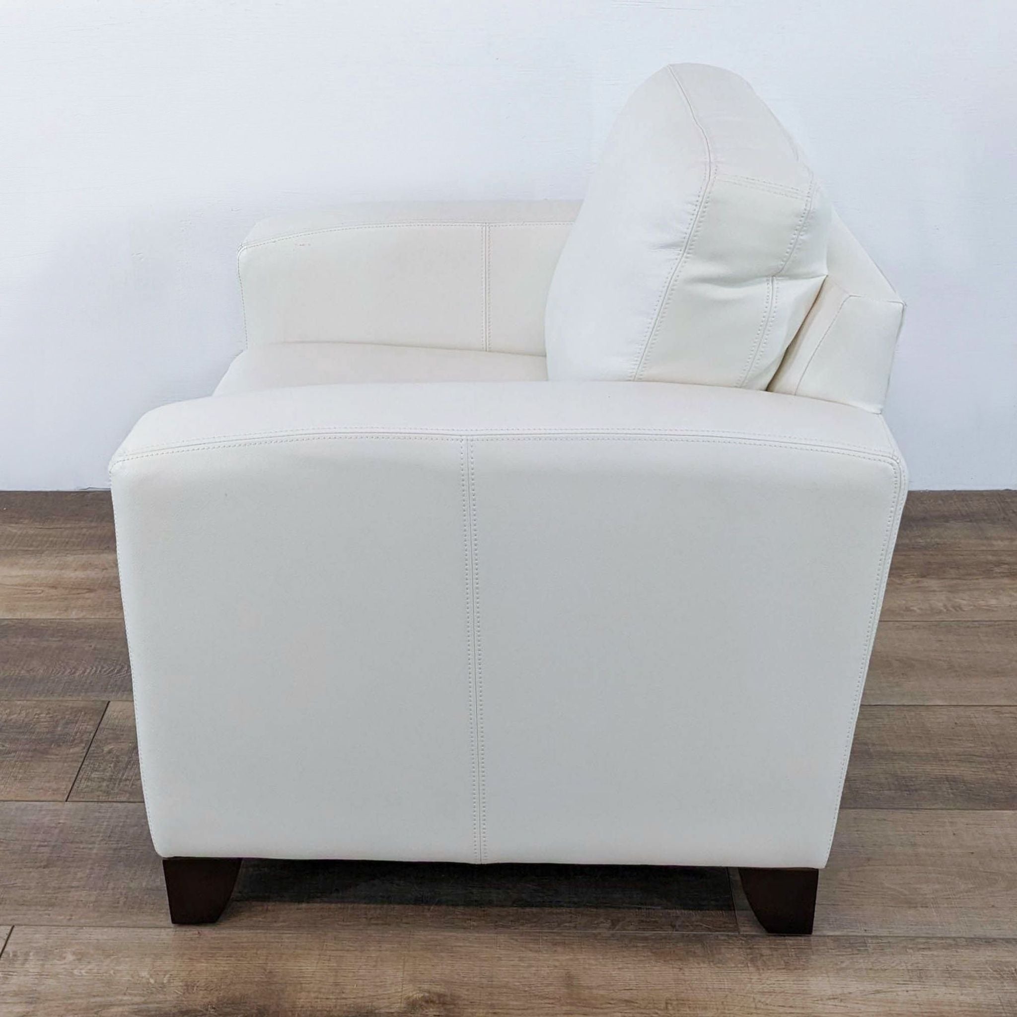 Reperch Leather Armchair, kiln-dried frame, no sag springs, cream color, on hardwood floor.