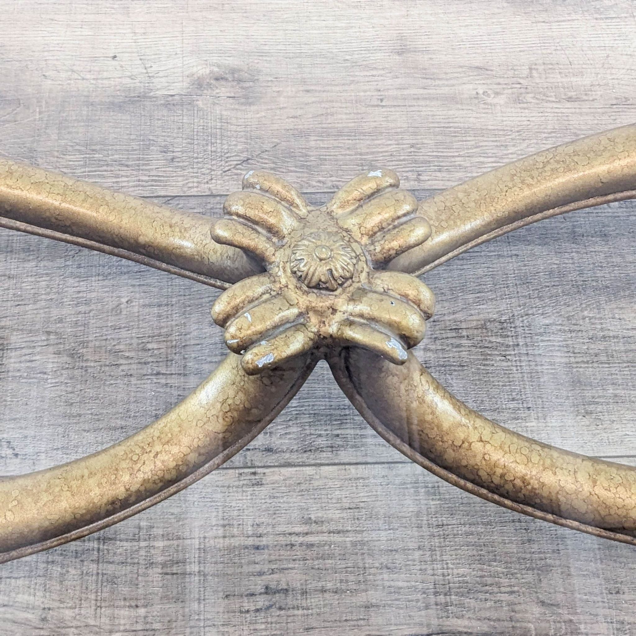 Close-up of Reperch coffee table's cast metal embellishments on antiqued base, showing detailed craftsmanship.