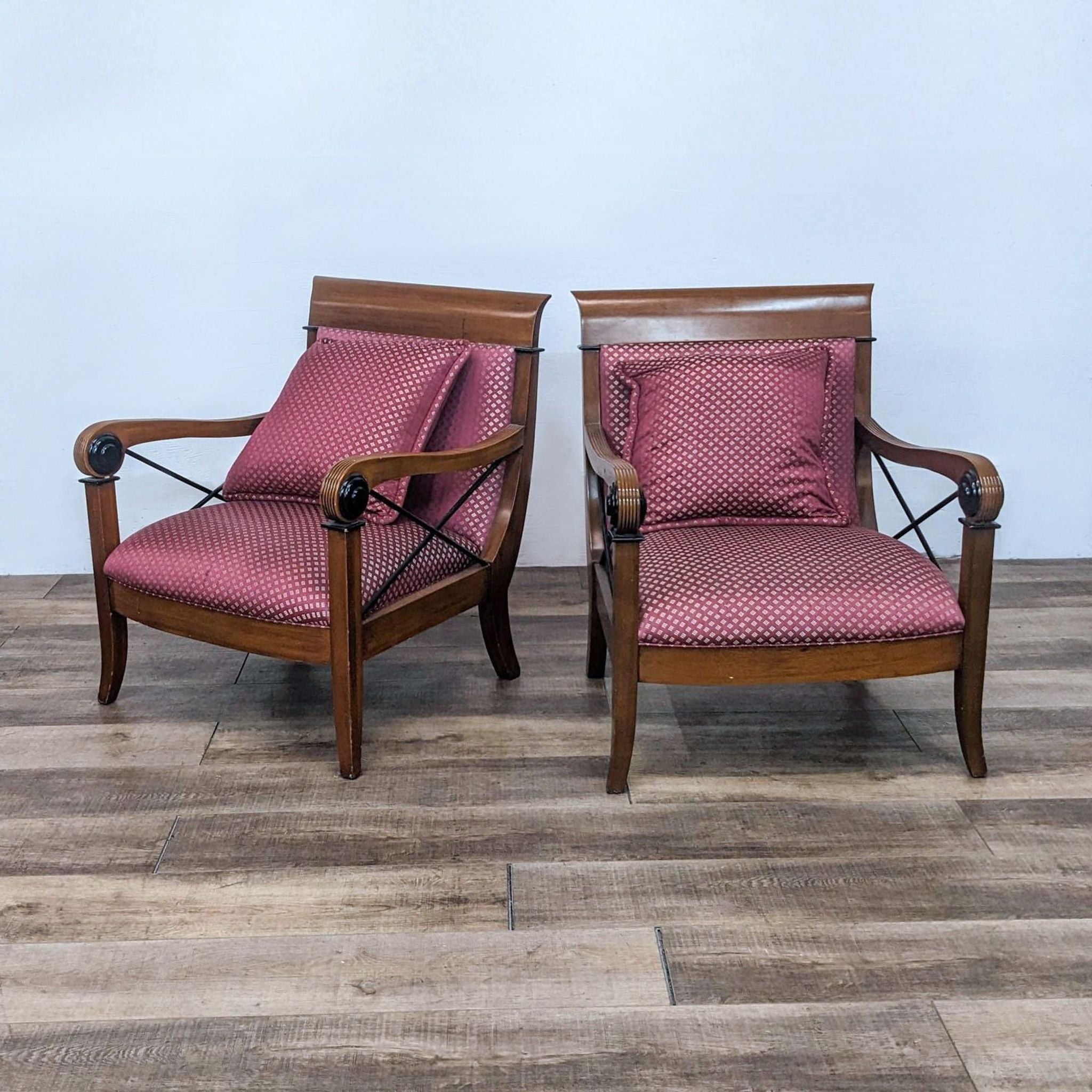 Alt text 1: Two Reperch lounge armchairs with wood frames, red upholstery, and X-side detailing, on a wooden floor.