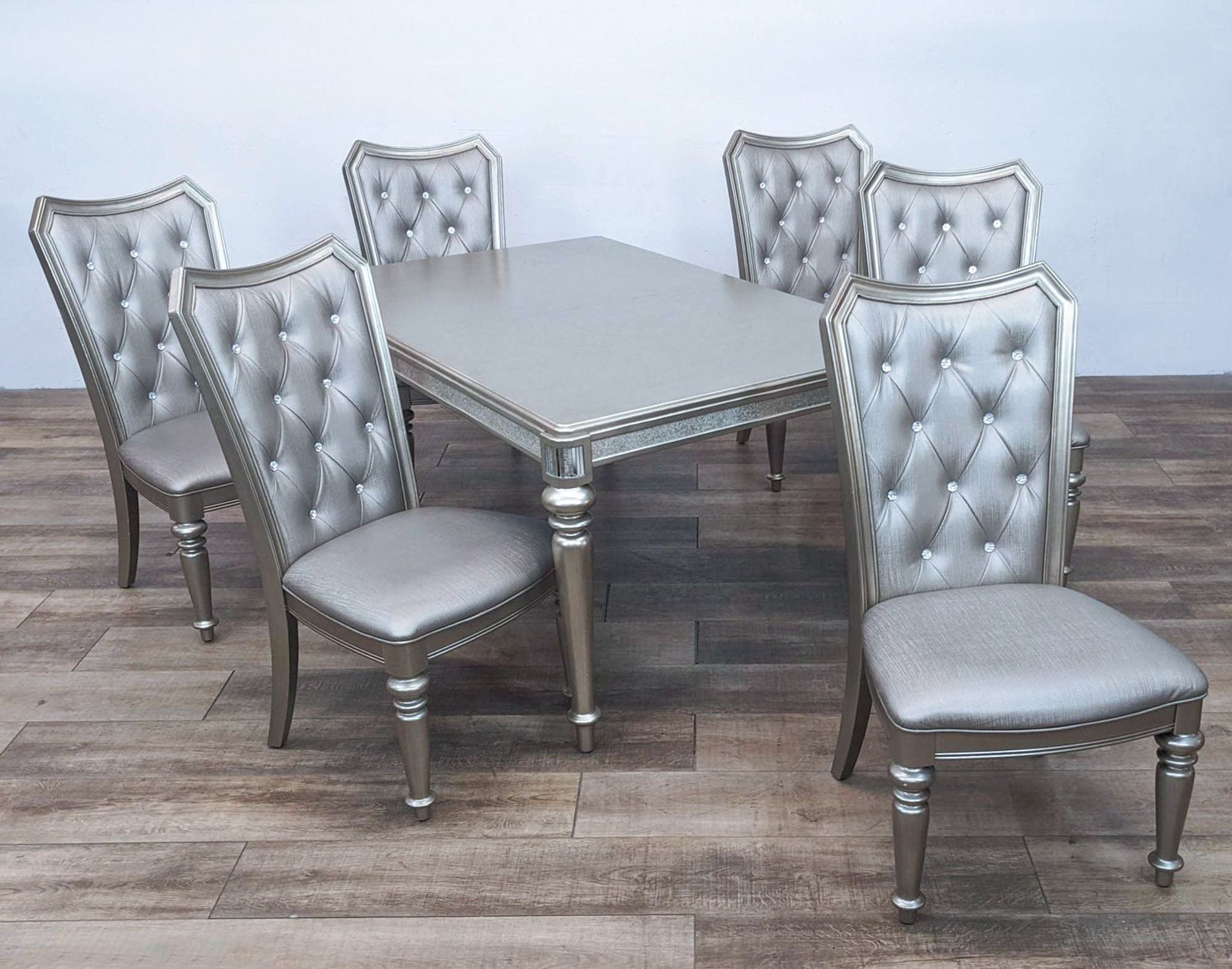 Alt text 1: Coaster 7-piece Danette dining set with a metallic platinum finish, mirrors, tufted chairs with crystal buttons, and faux leather.