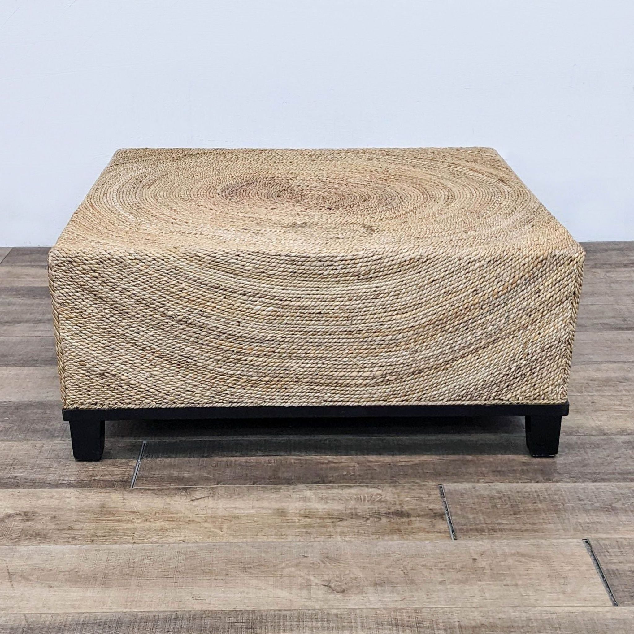 Reperch brand coffee table with natural fiber woven top and black legs on a wooden floor.