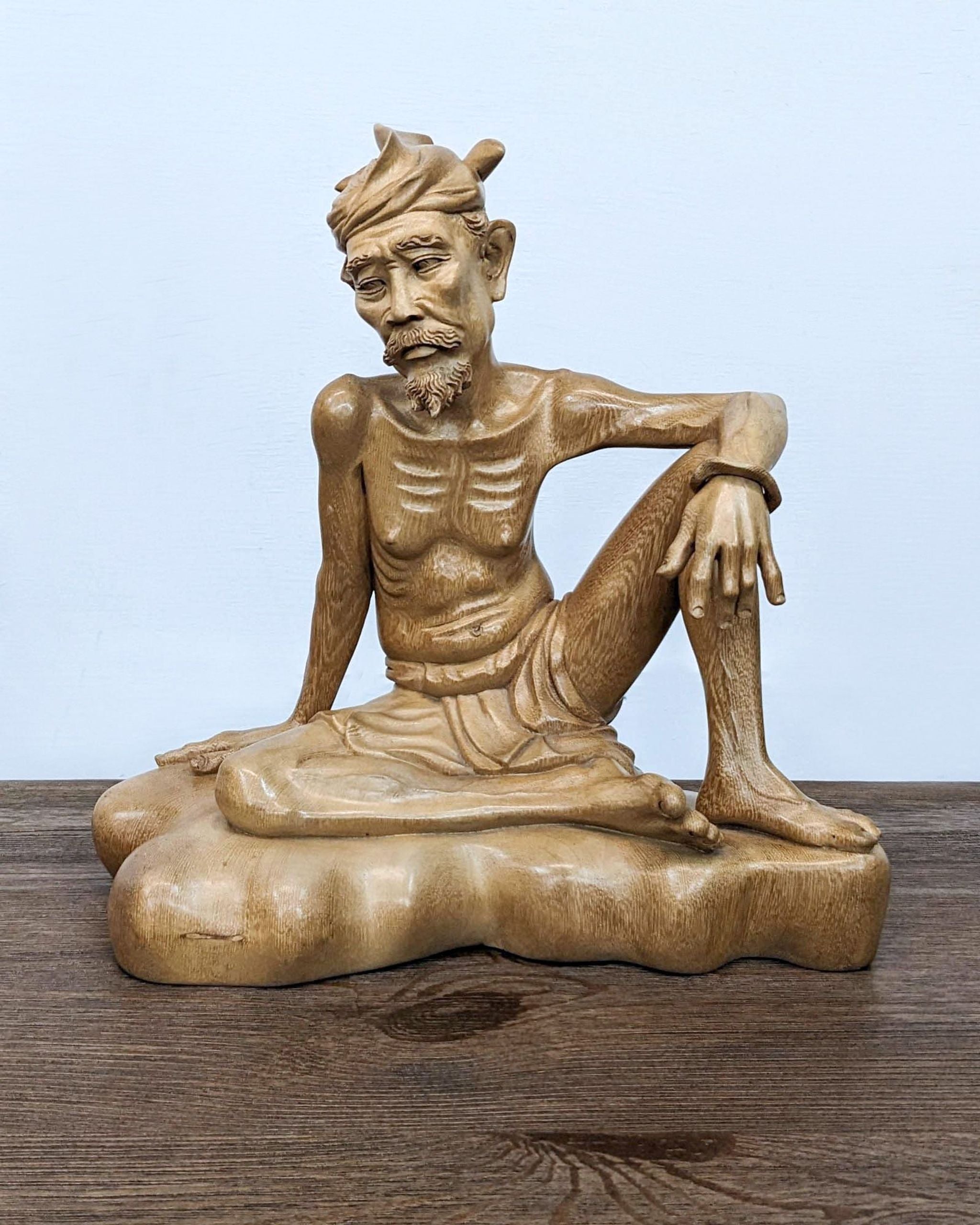 1. Vintage Ida B Marka Bali crocodile wood statue of a seated man with thoughtful expression, displayed against a plain background.