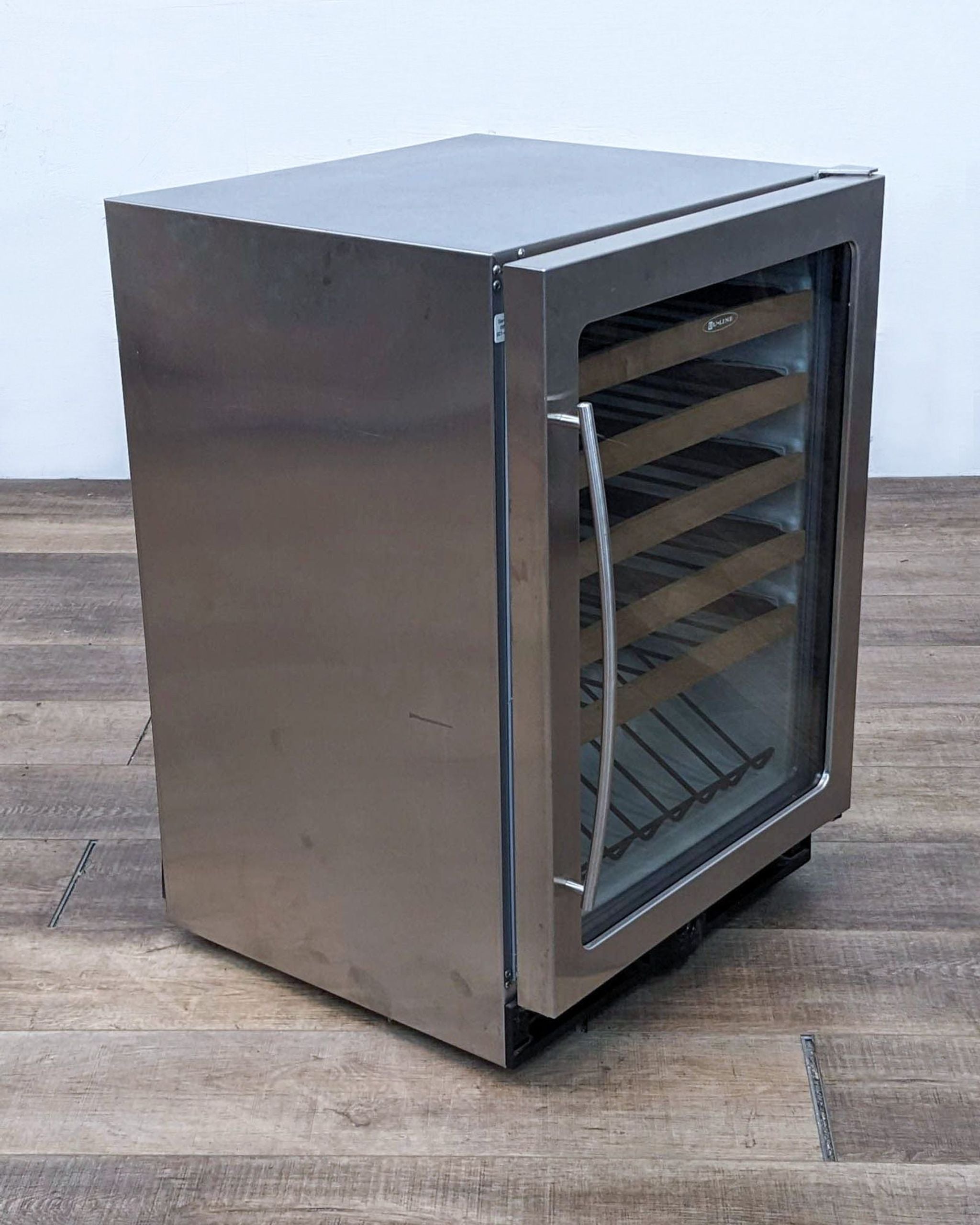 Stainless steel U-Line refrigerator, door ajar, showcasing internal racking, with a side view of its sleek design.