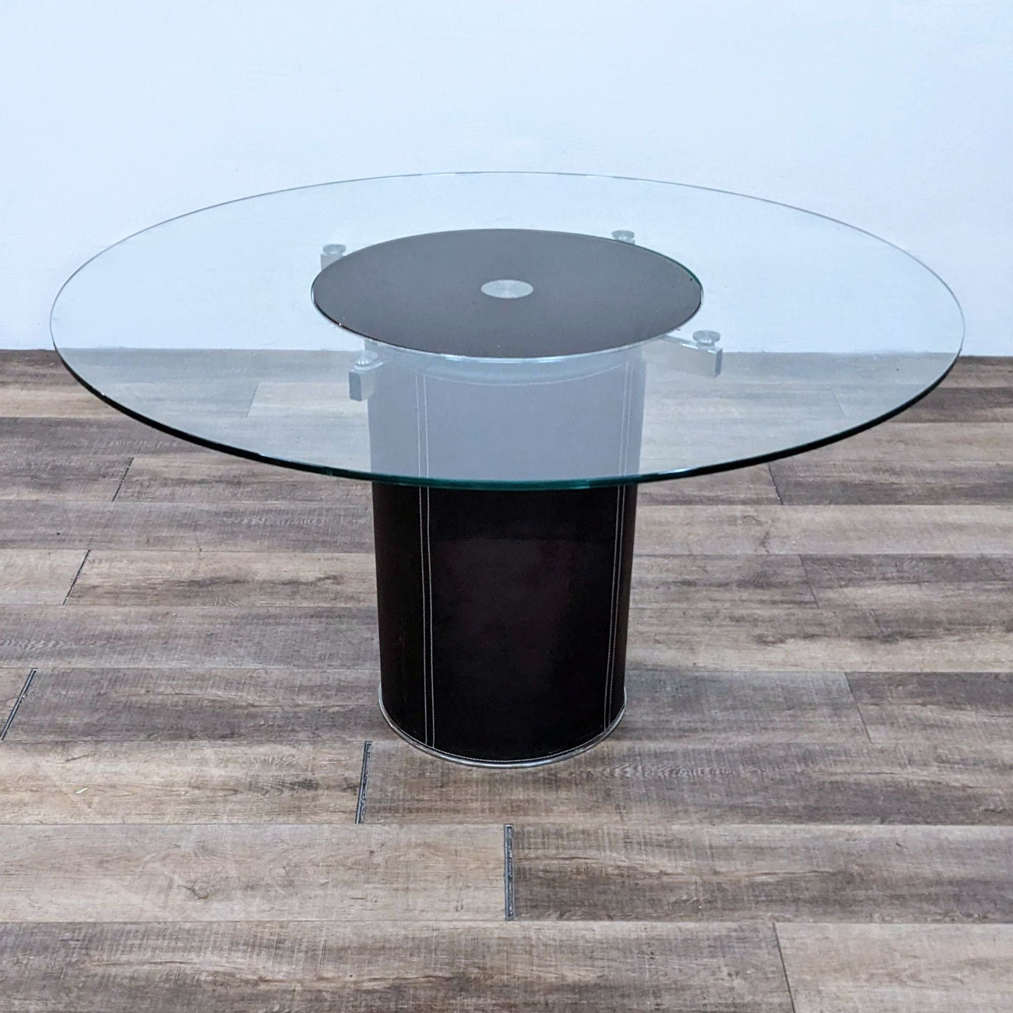 Round Lauss dining table with a tempered glass top and revolving tray on a stainless steel and leather-wrapped base by Scandinavian Design.